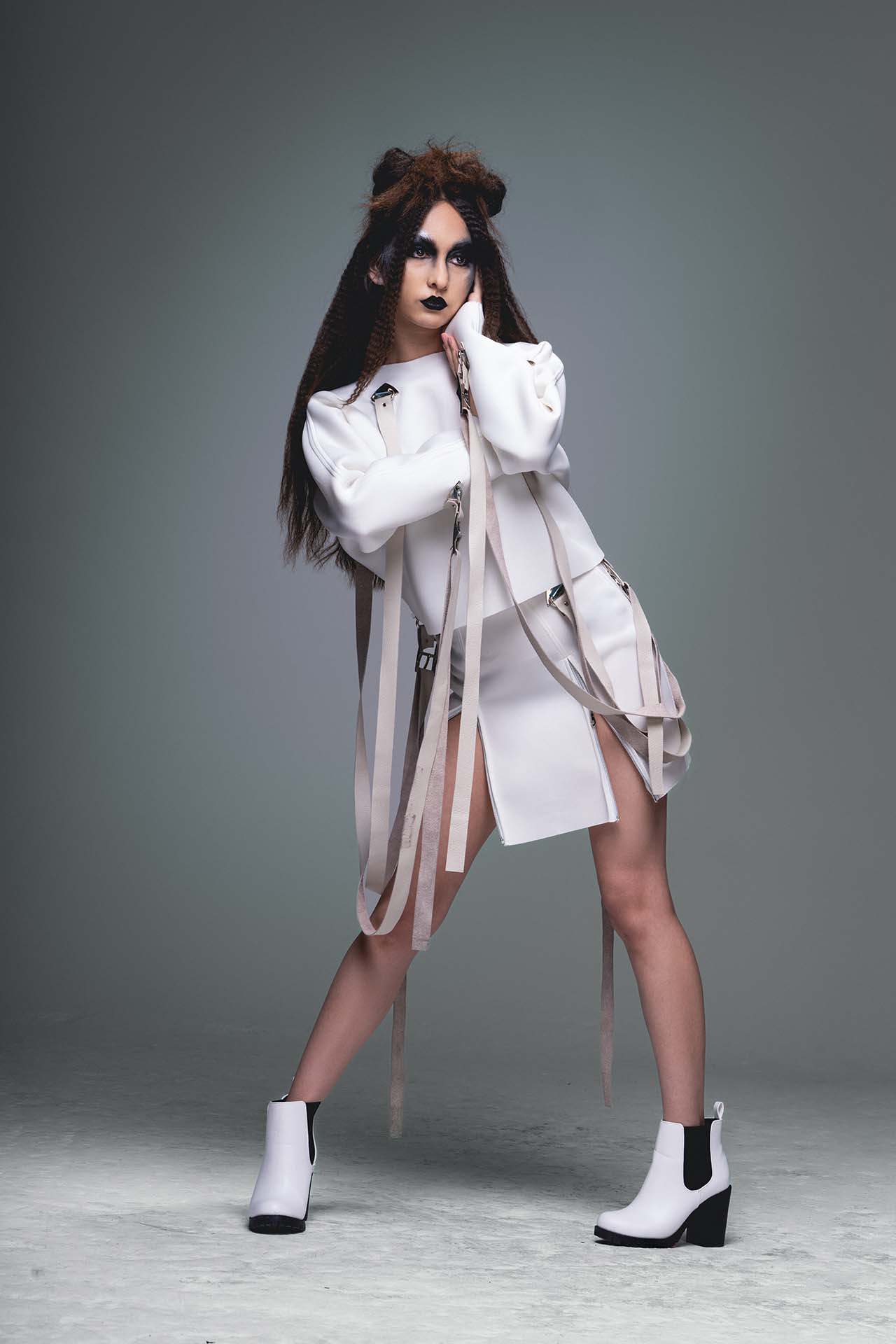 Model in a white dress with ribbon detail, dynamic studio fashion photography