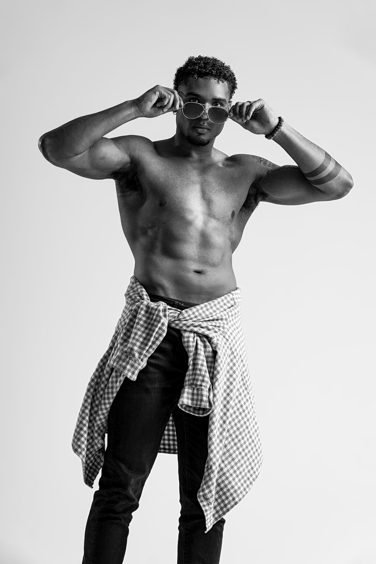 Male model in a color-block black and white shirt and jeans, standing studio portrait