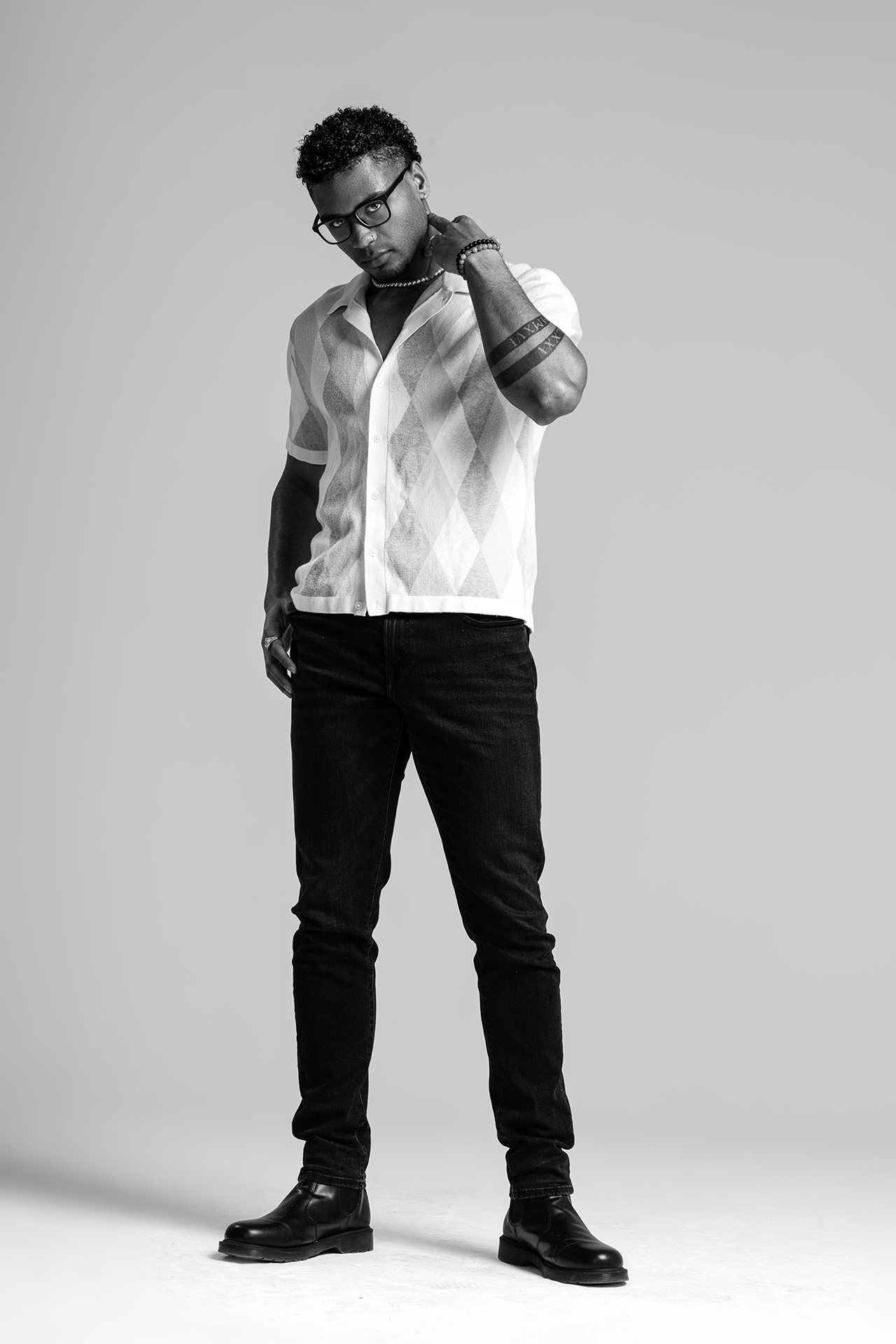 Shirtless male model in a leather jacket and jeans, casual studio portrait