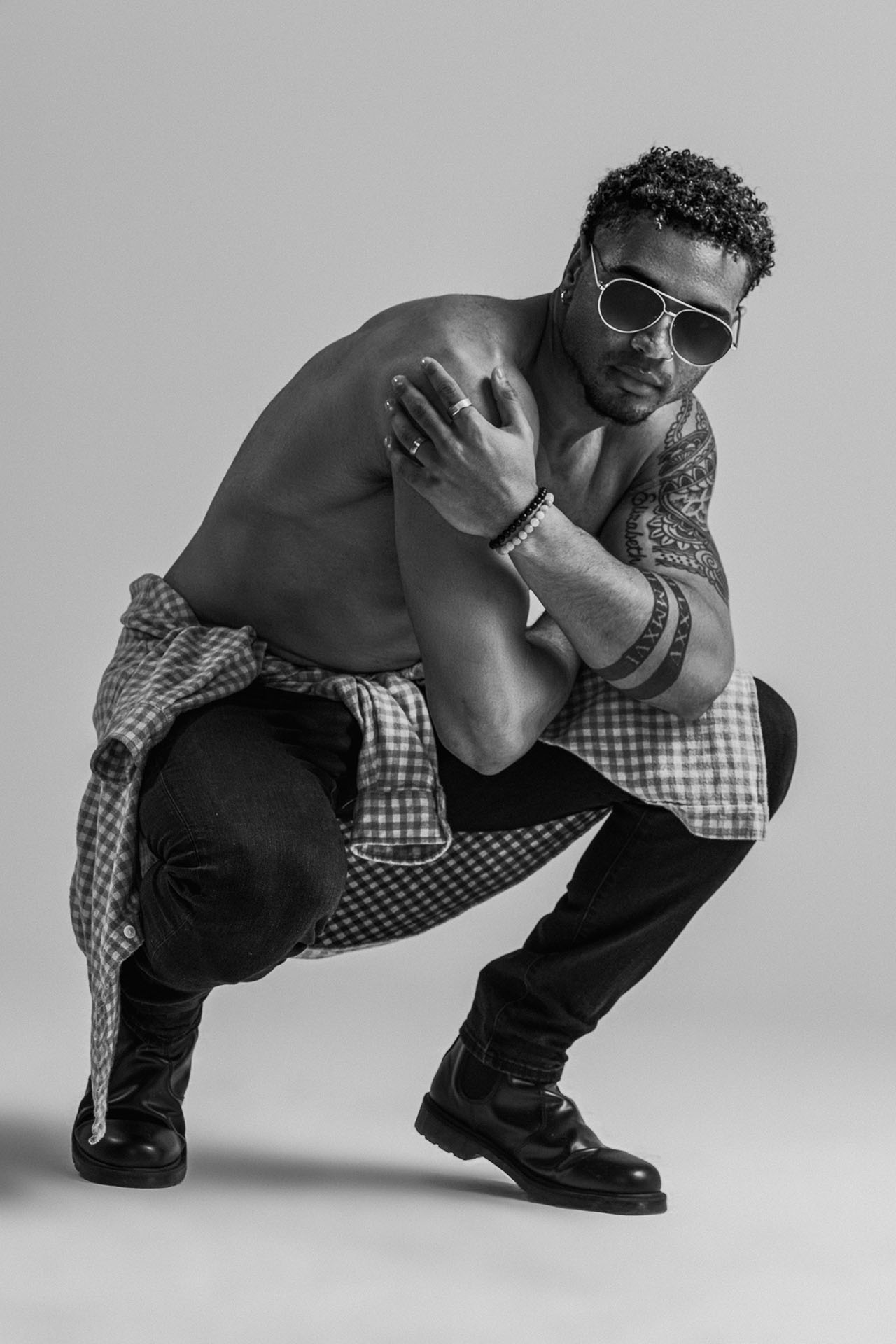 Male model in a red jumpsuit with a white sash, dynamic editorial studio photography