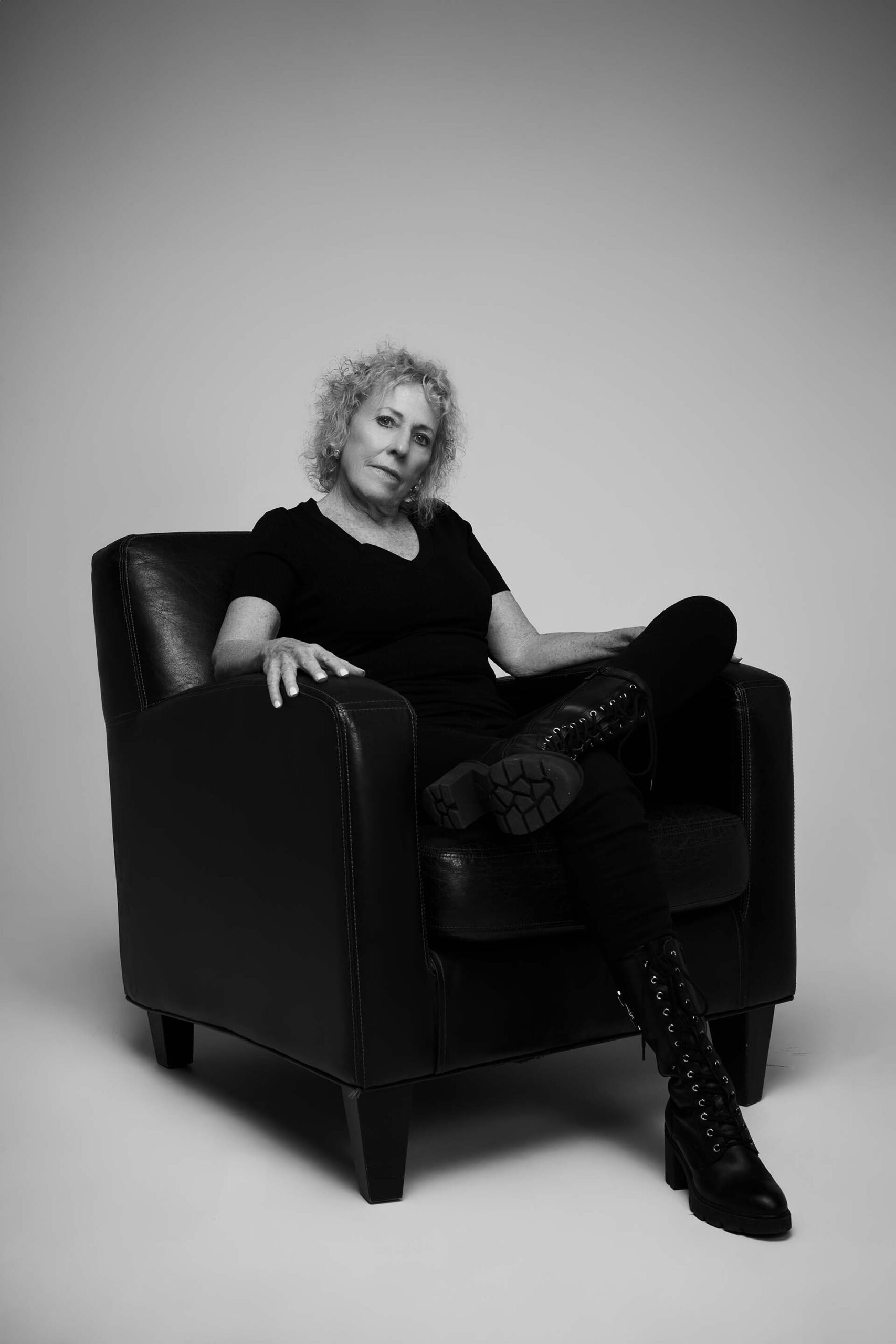 Black-and-white portrait of a woman standing in a slight forward-leaning pose