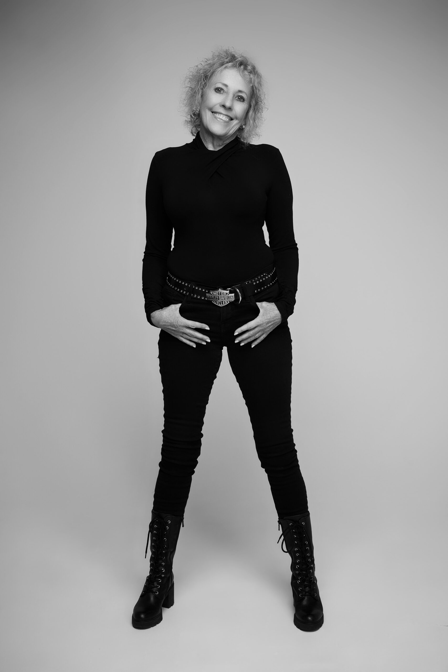 Black-and-white full-body portrait of a woman in a side-angle standing pose
