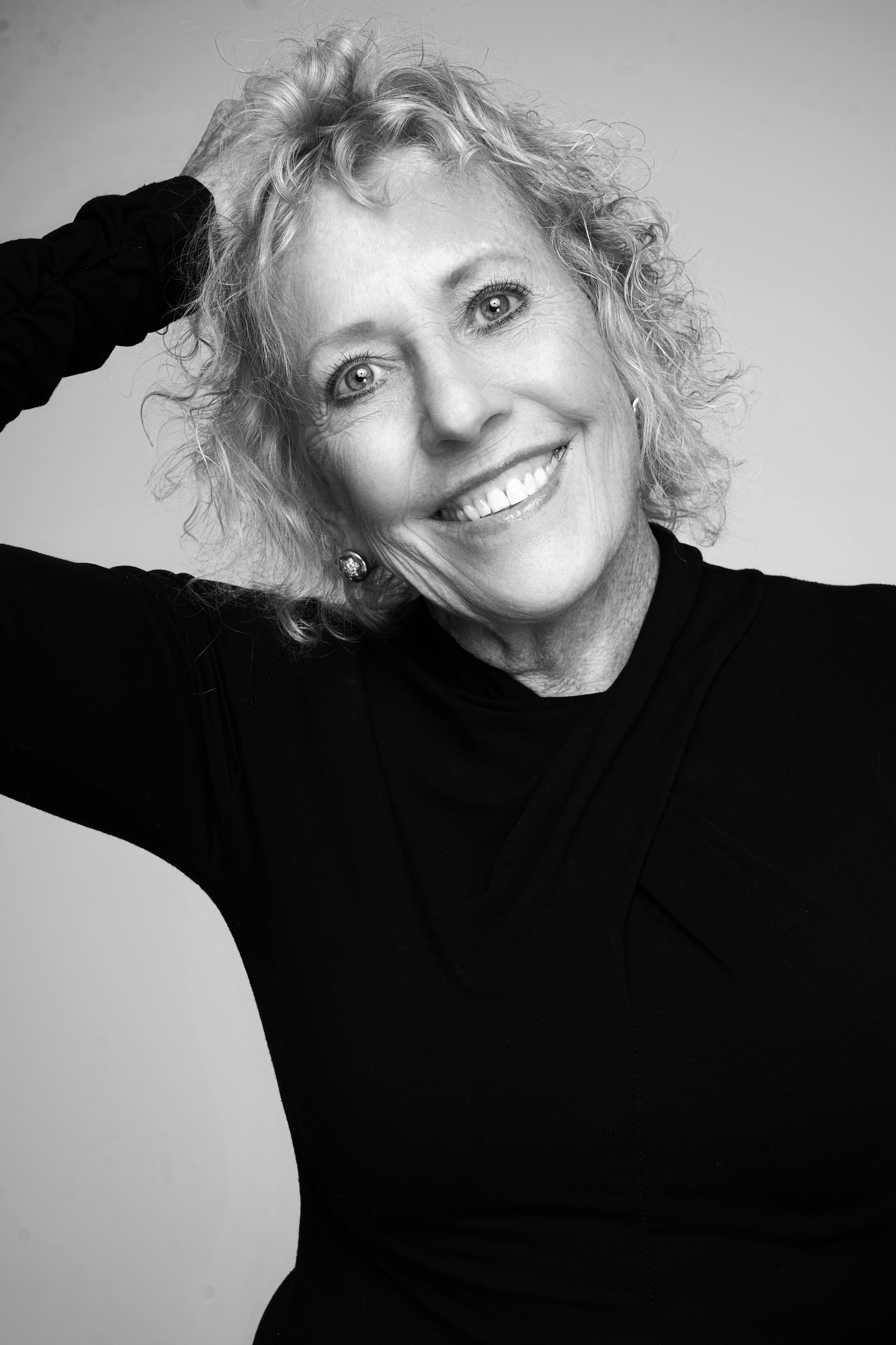 Black-and-white smiling portrait of a woman with arms crossed