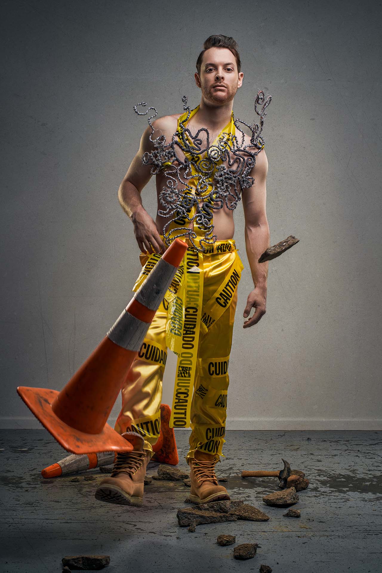 Male model in a yellow caution-tape outfit, avant-garde editorial photography