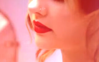 Artistic close-up beauty shot with motion blur and bold red lipstick, pink and red tones