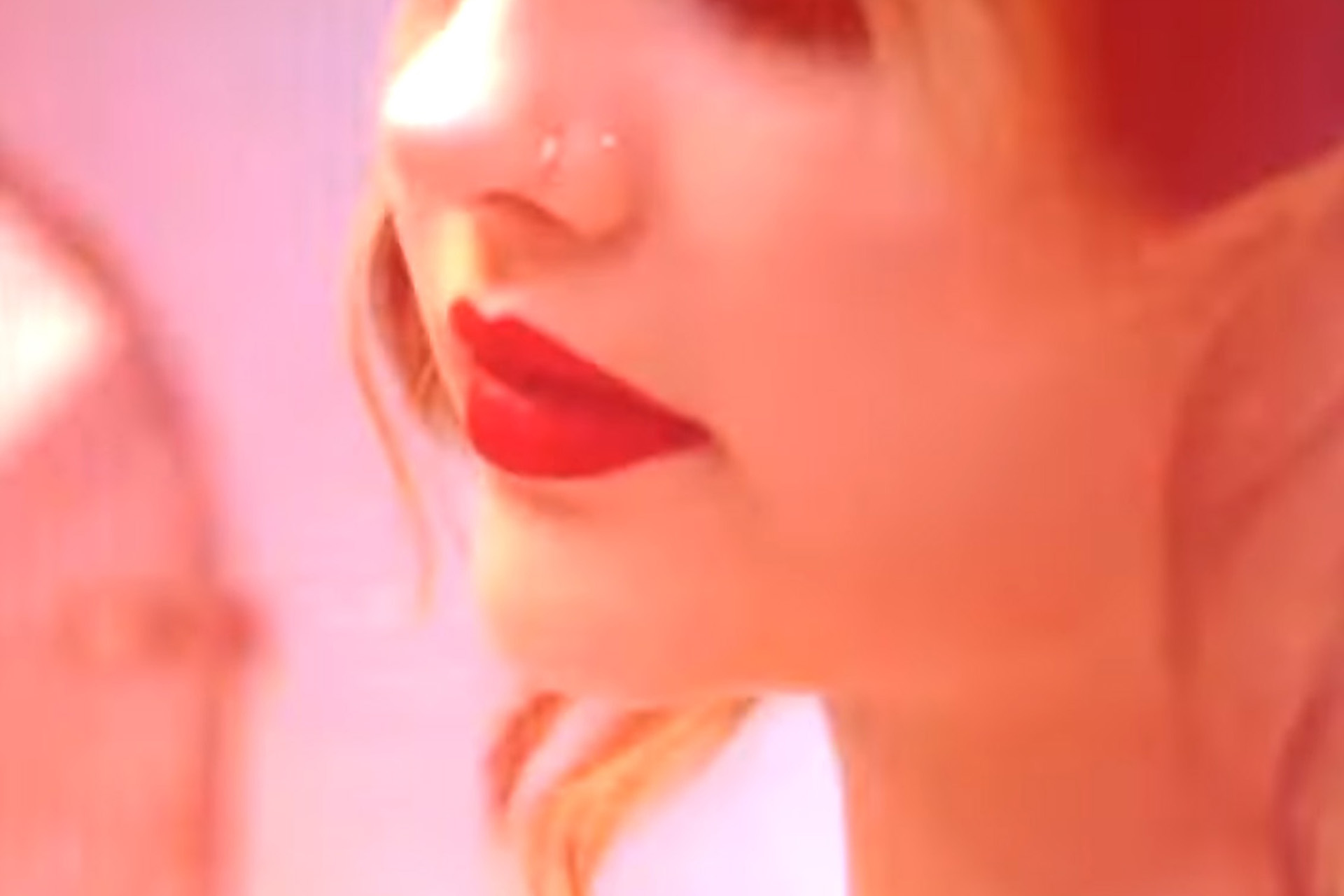 Artistic close-up beauty shot with motion blur and bold red lipstick, pink and red tones