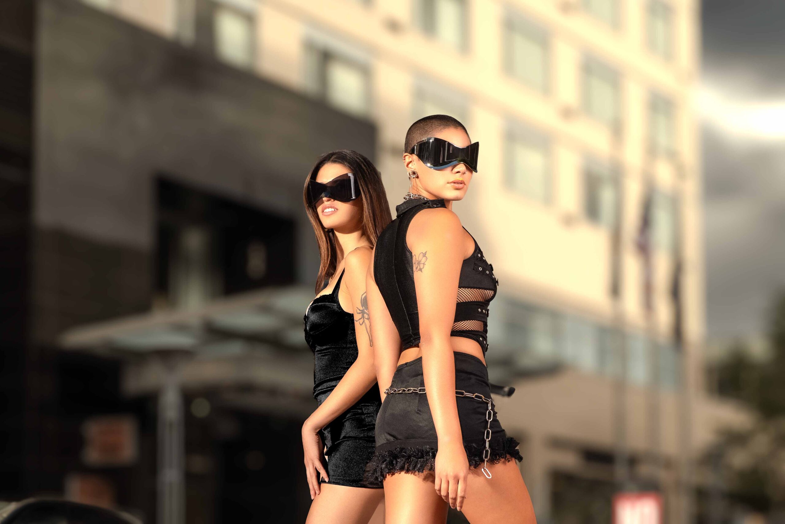 Adi Editorial Fashion Photography 01 Two models in black outfits and sunglasses walking together on an urban city street