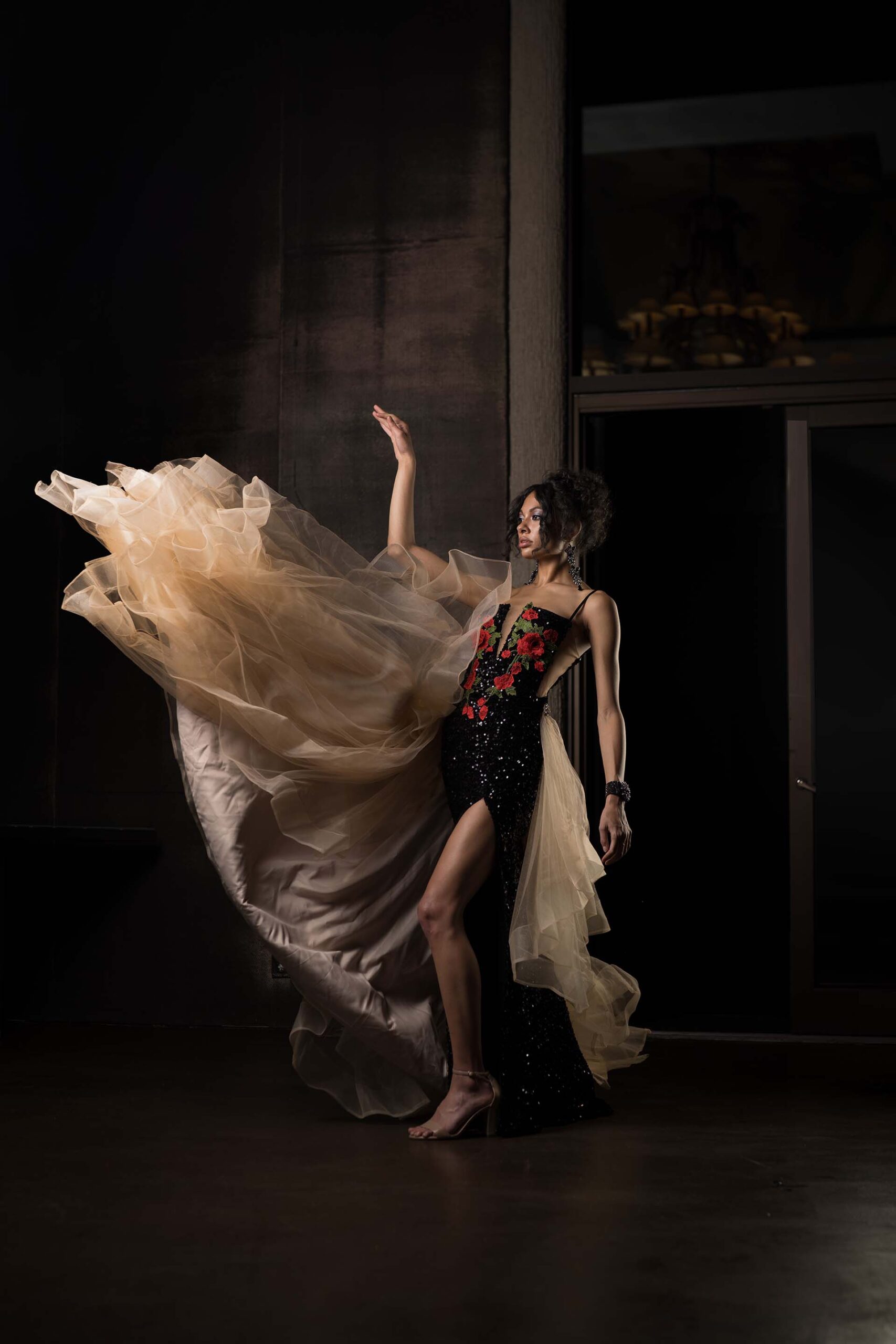 Model in a flowing champagne-colored gown captured mid-motion at the Cableland Venue