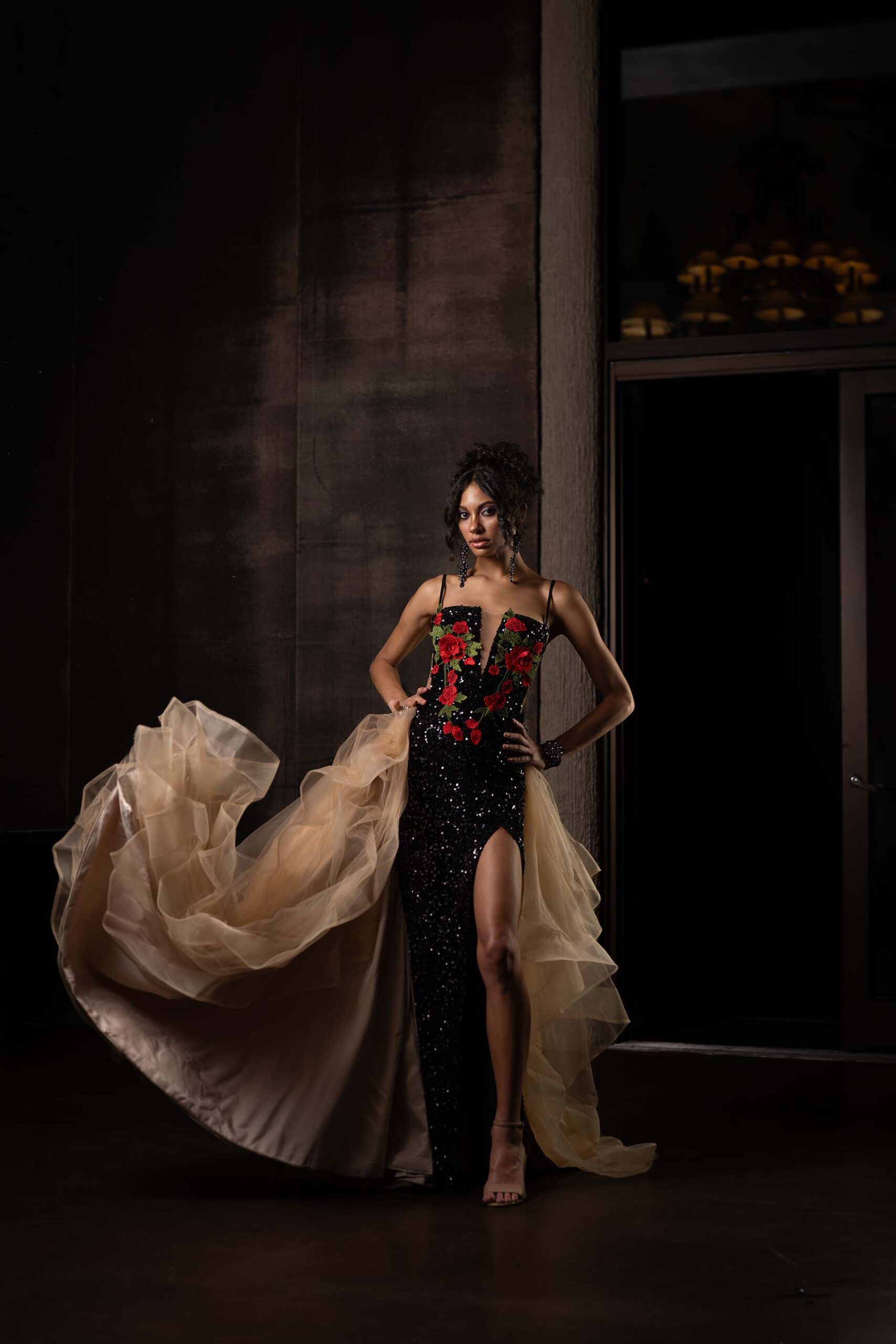 Model in a black and red gown with a flowing champagne train, at the Cableland Venue