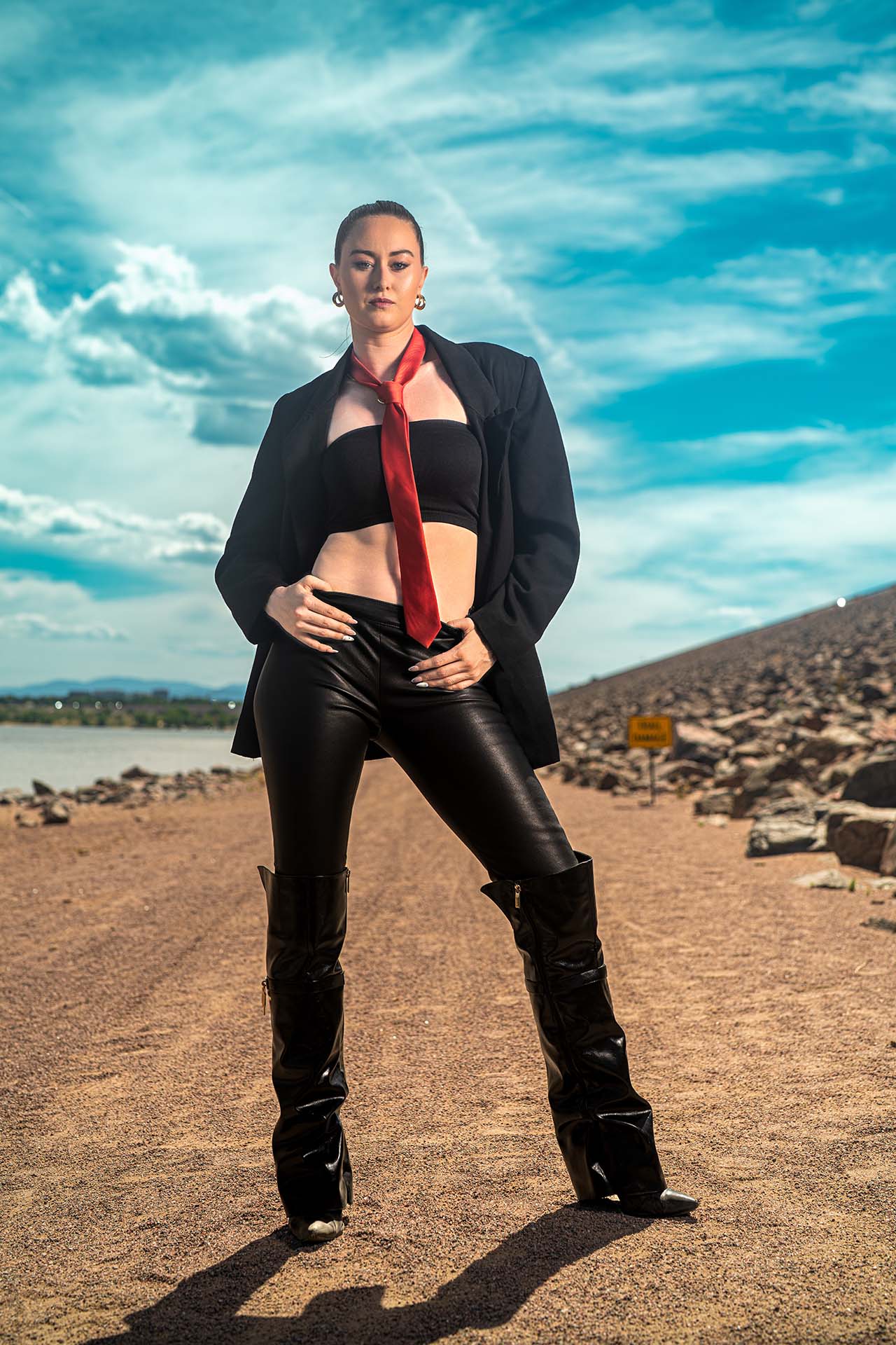 Ashlee standing in a black and red outfit at Cherry Creek Reservoir, wide dramatic sky
