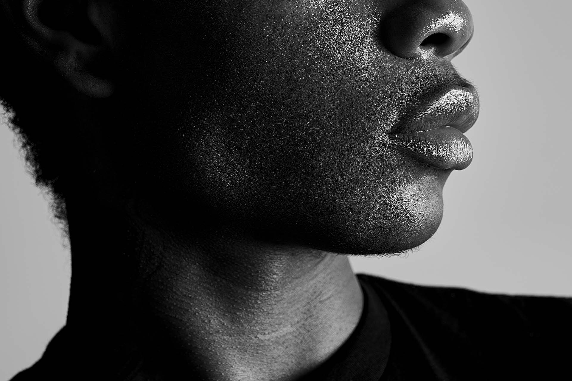 Black-and-white close-up portrait focusing on the lips and jawline, fine-art photography