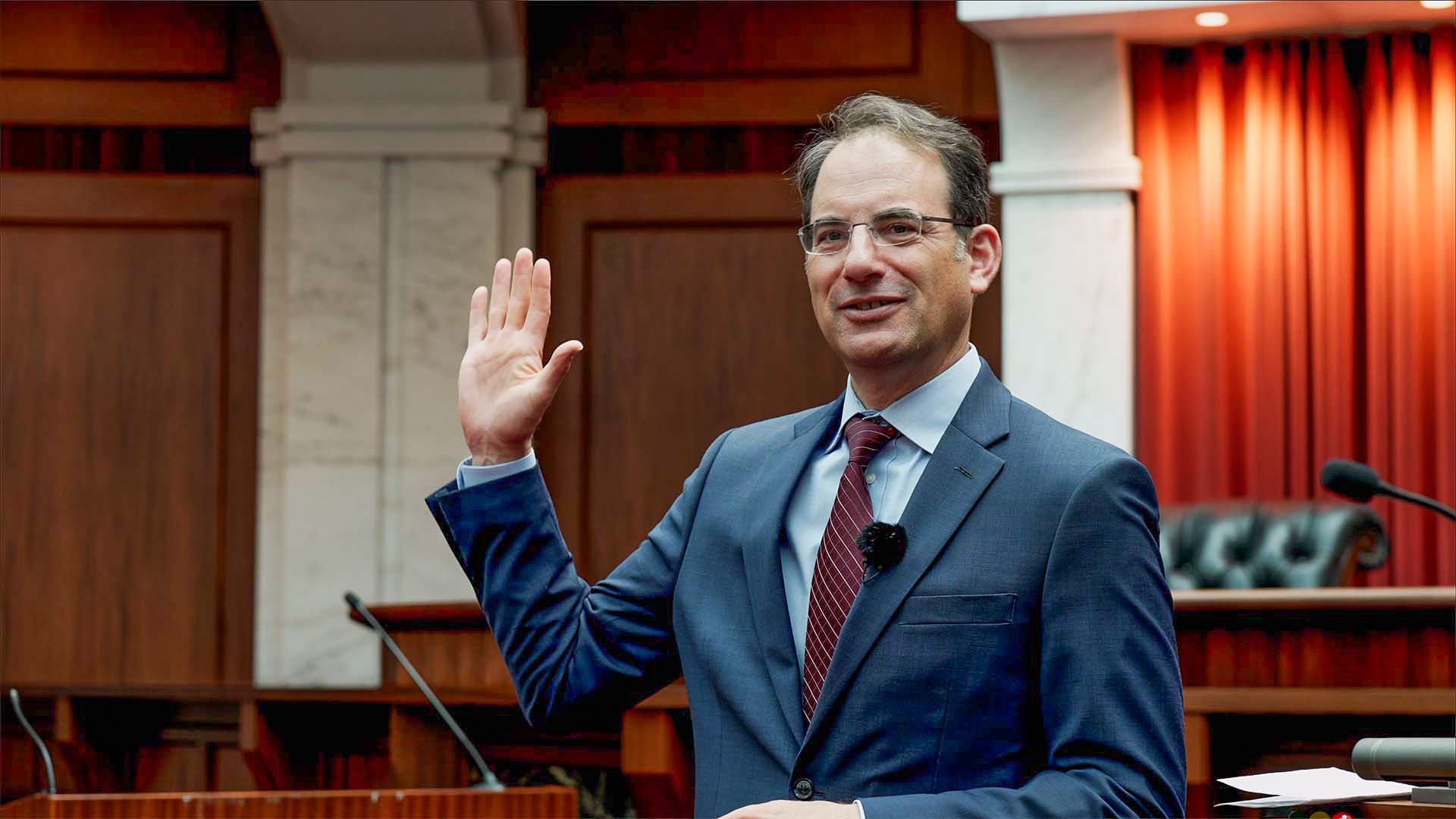 Colorado Attorney General Phil Weiser raising his right hand during a swearing-in at a courtroom legal event