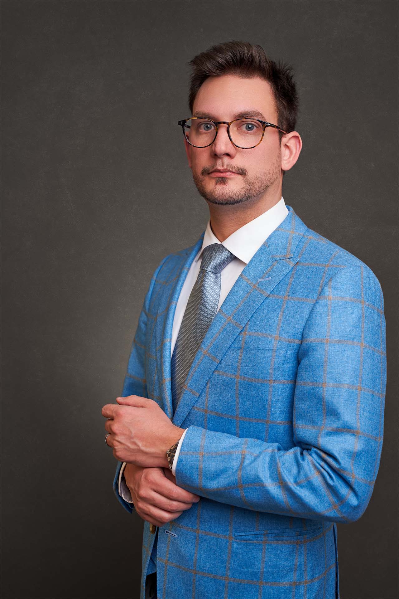Man in a blue plaid suit and glasses, corporate advertising portrait
