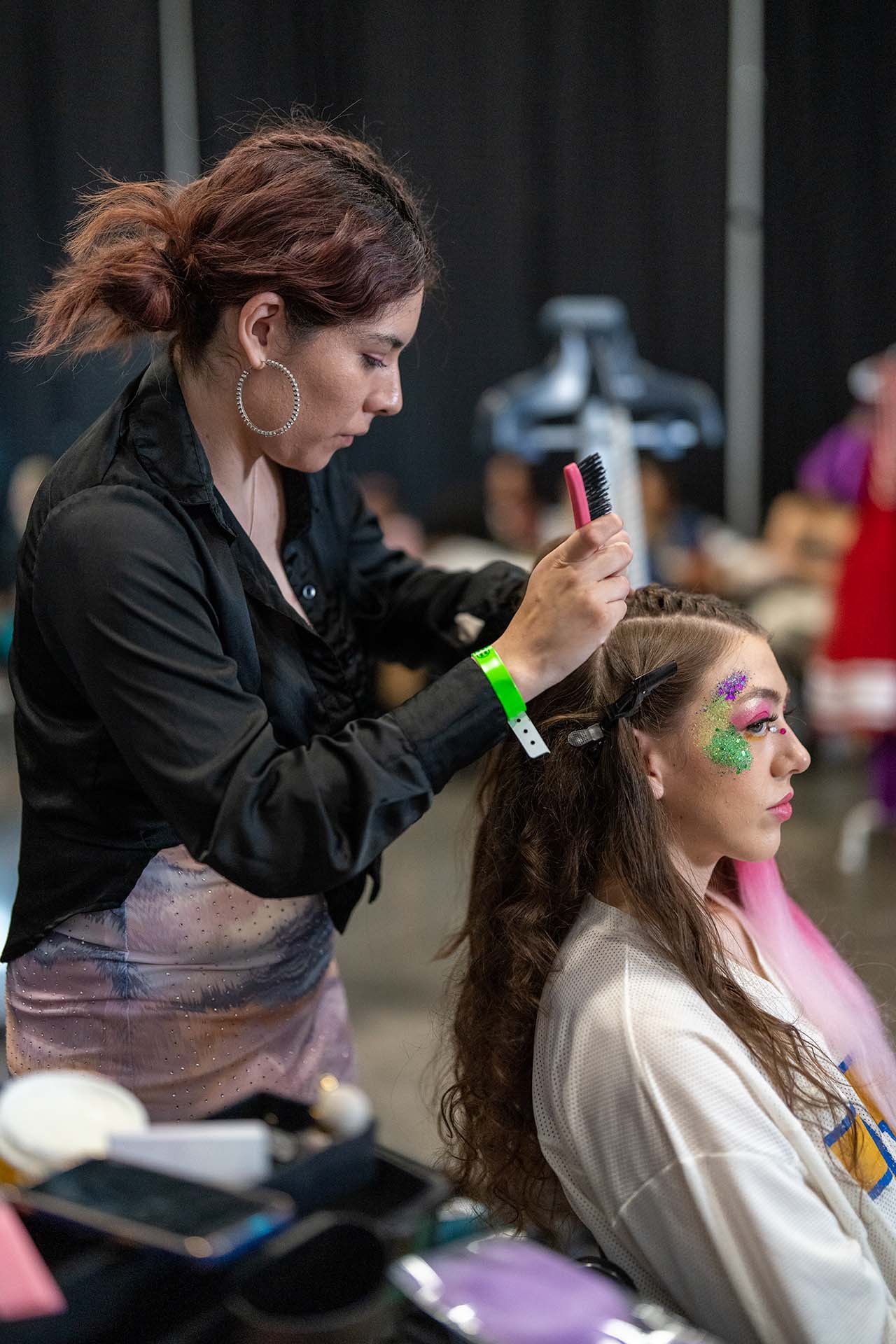 Backstage photo of a hairstylist artist working with a model at Denver Fashion Week