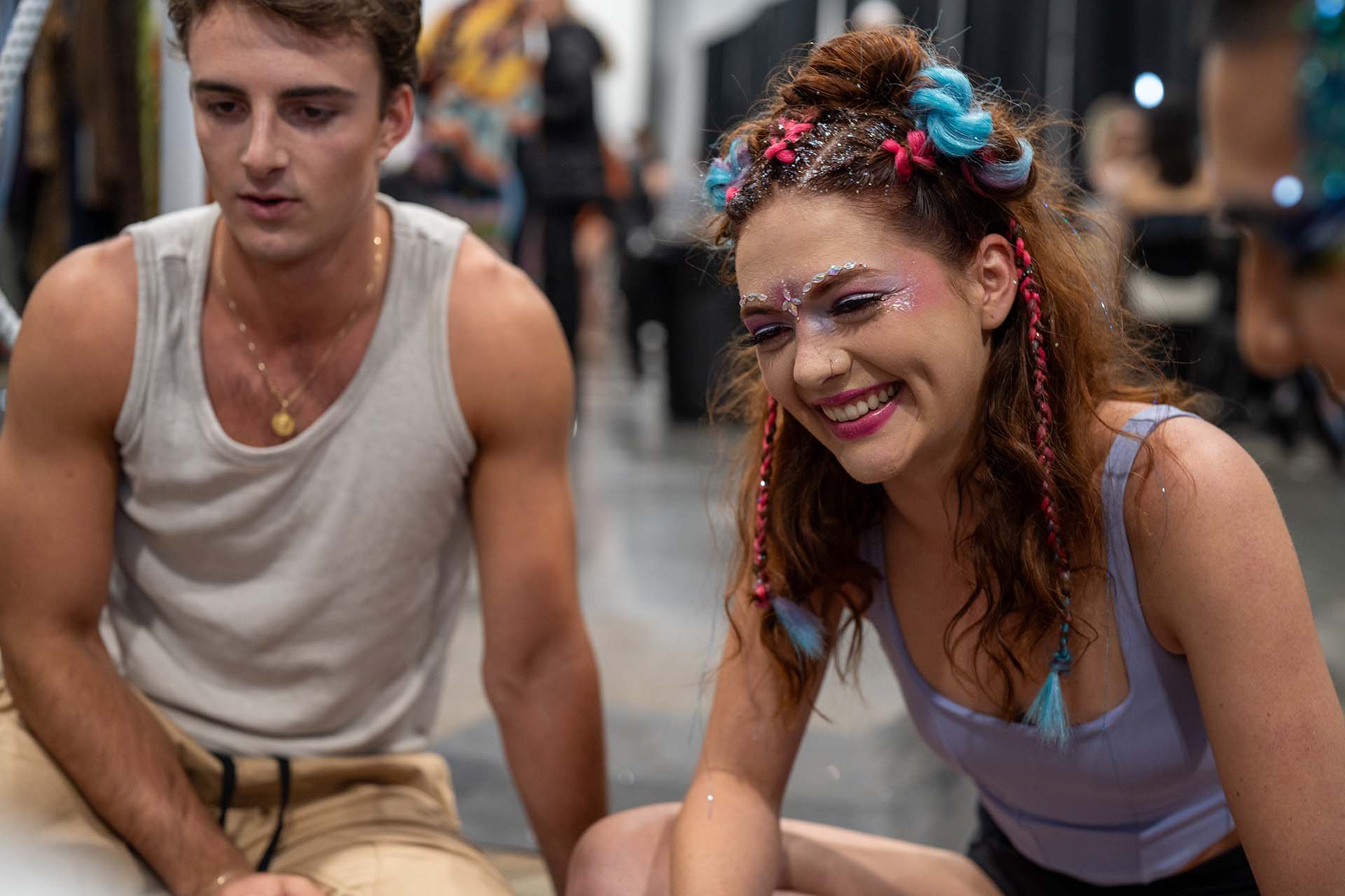 Candid backstage photo of two models seated together at Denver Fashion Week