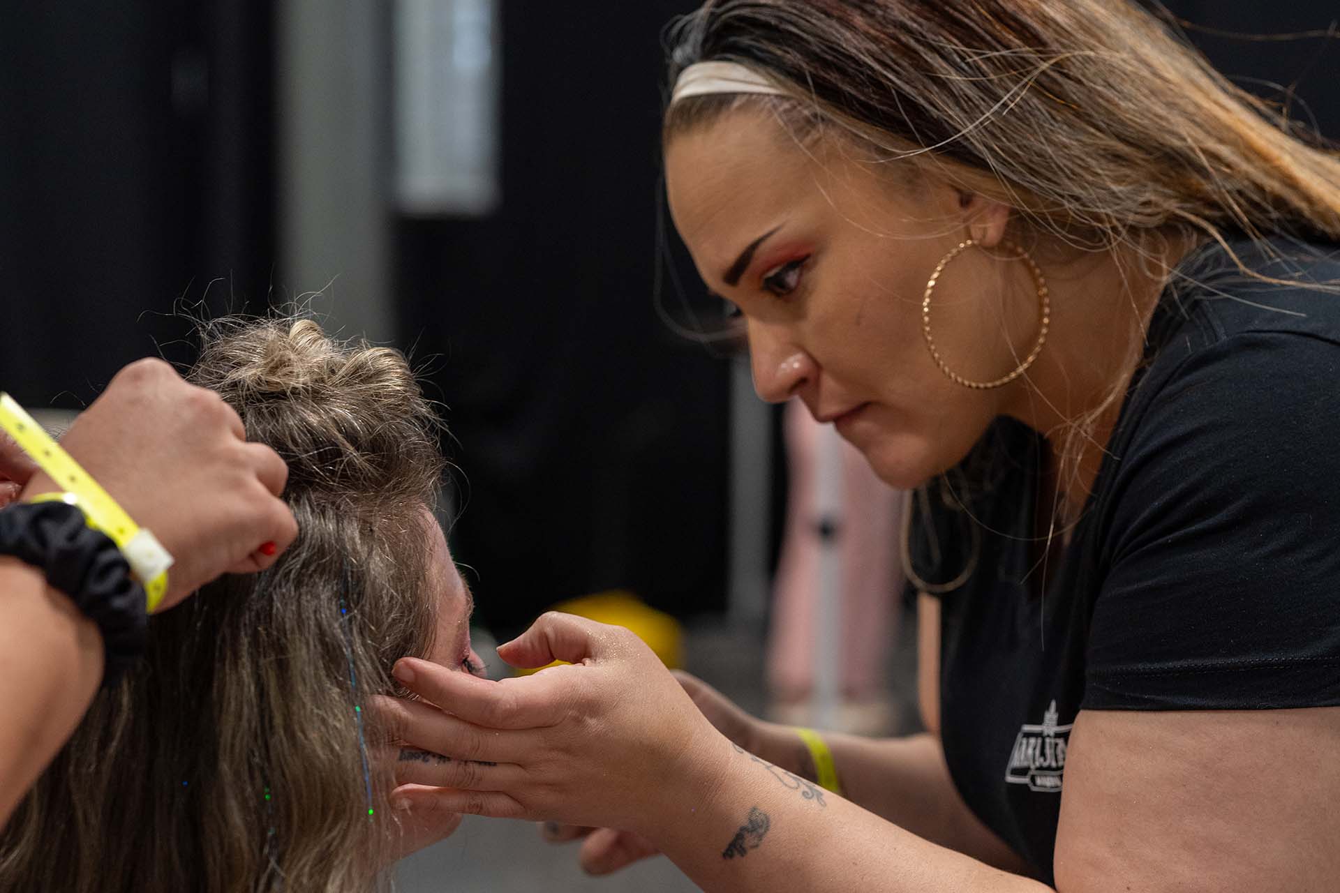 Backstage photo of a stylist working on a model's hair, first look, Denver Fashion Week