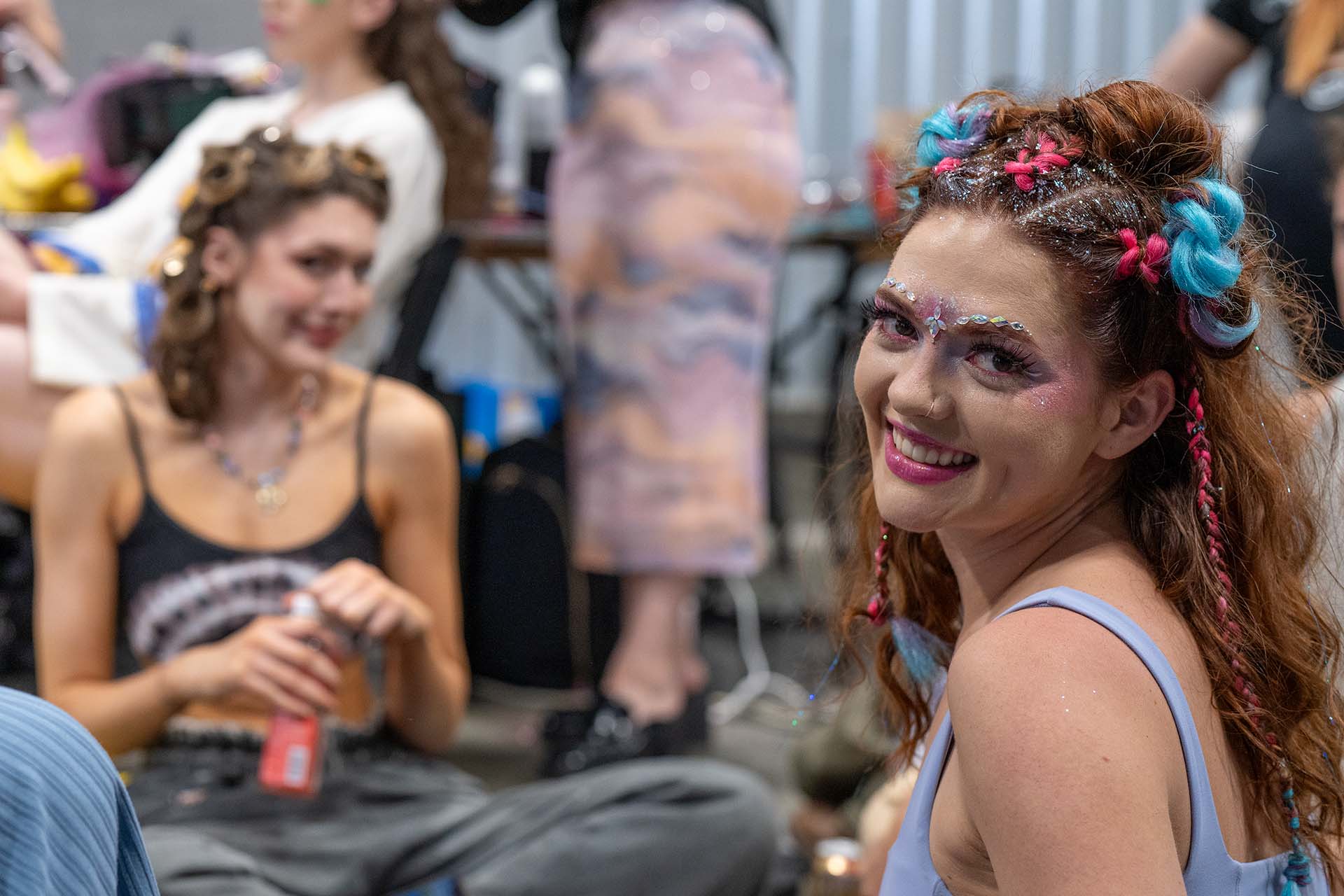 Group of models backstage with colorful hair accents, candid Denver Fashion Week photography