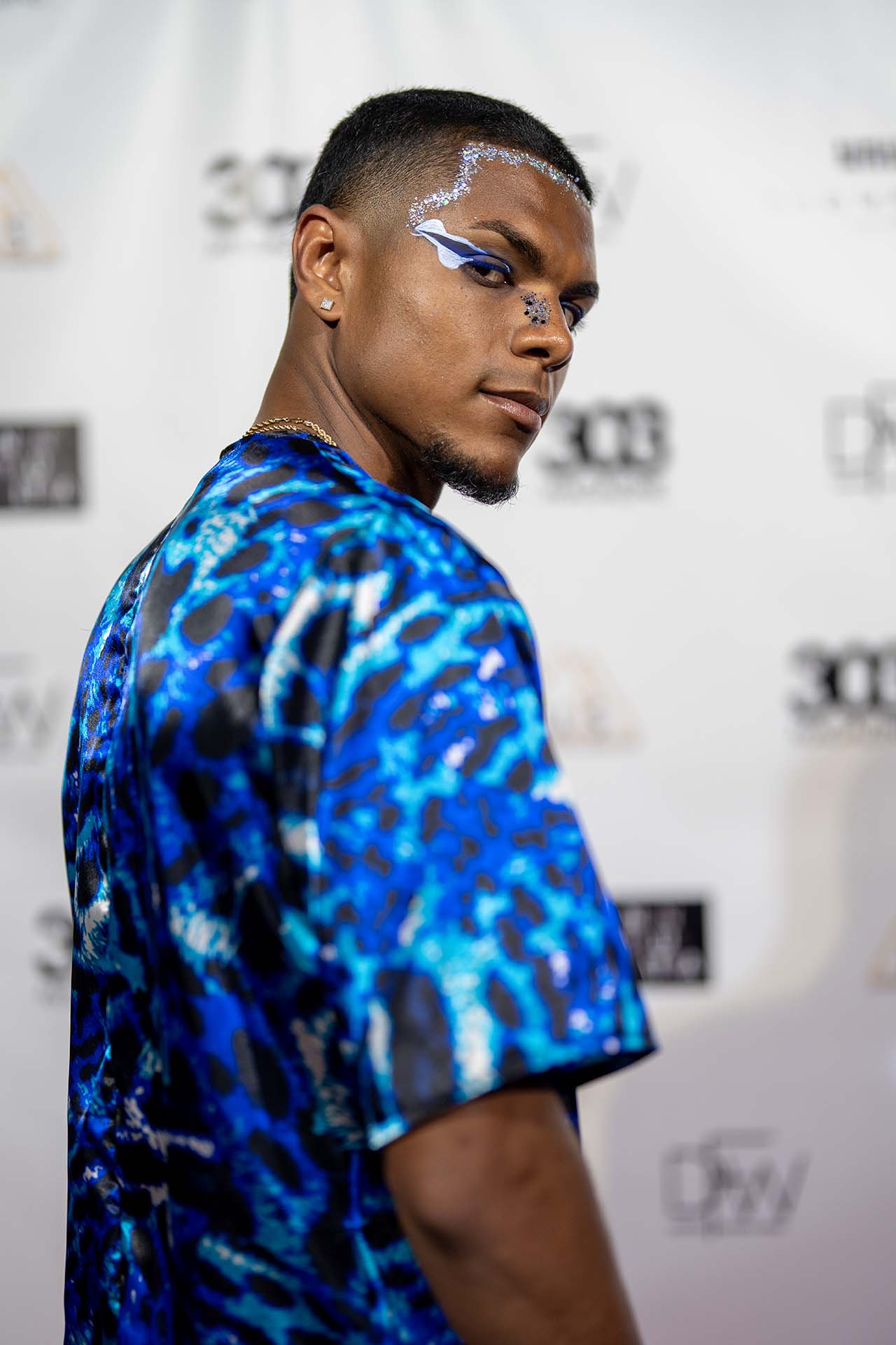 Runway model in a blue tie-dye shirt on the Denver Fashion Week red carpet