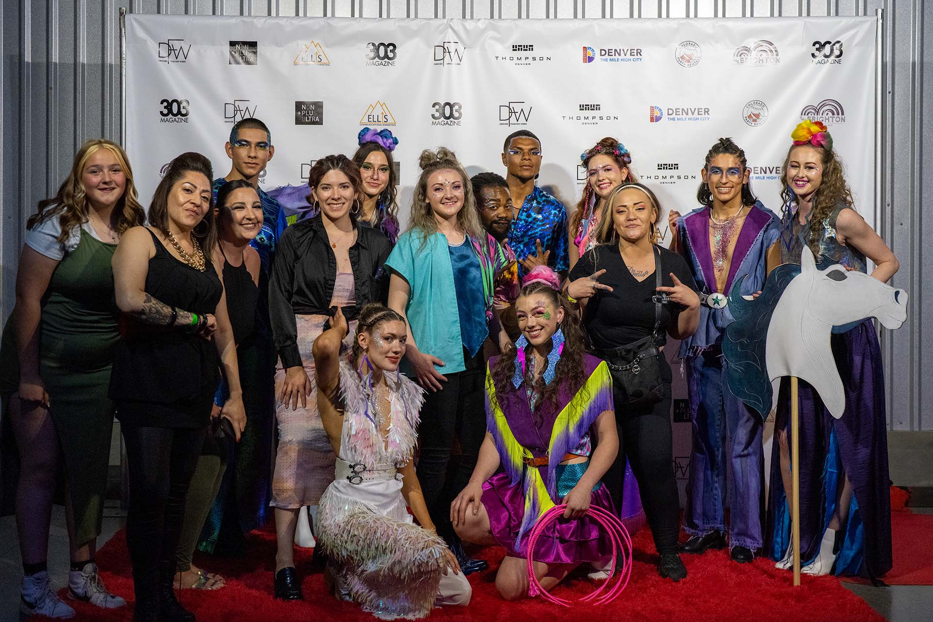 Large group photo of models and designer together on the Denver Fashion Week red carpet