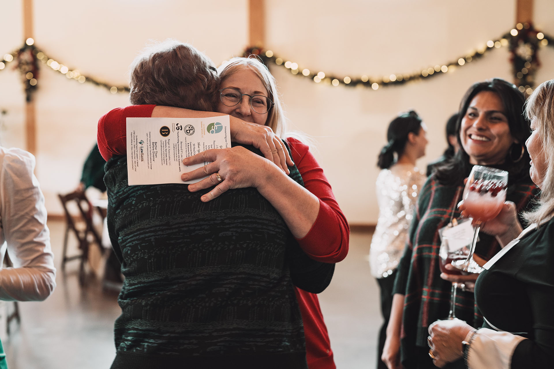 Candid photo of two guests embracing in a warm greeting at an event