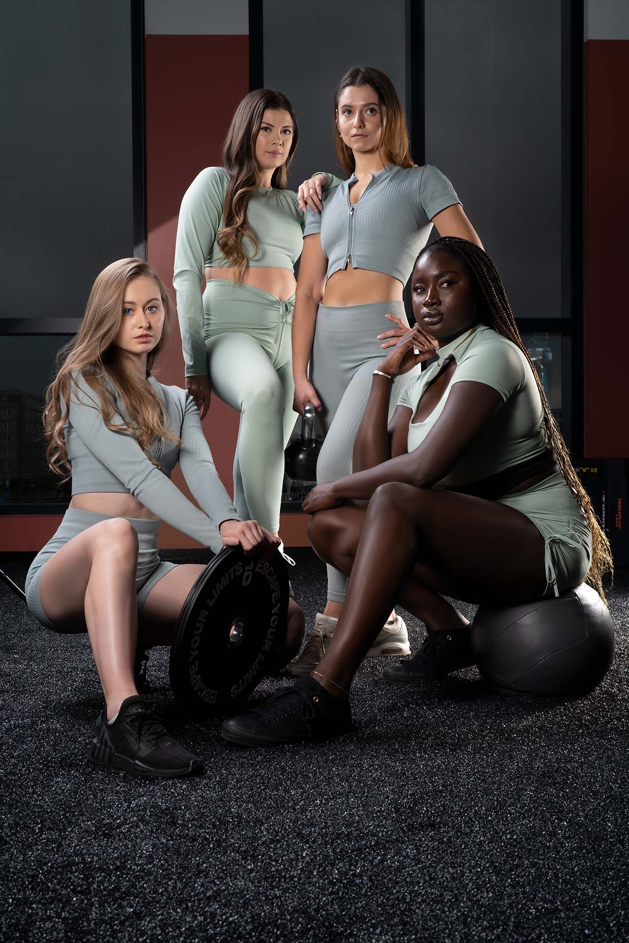 Group of women in athletic wear posed together in a studio setting