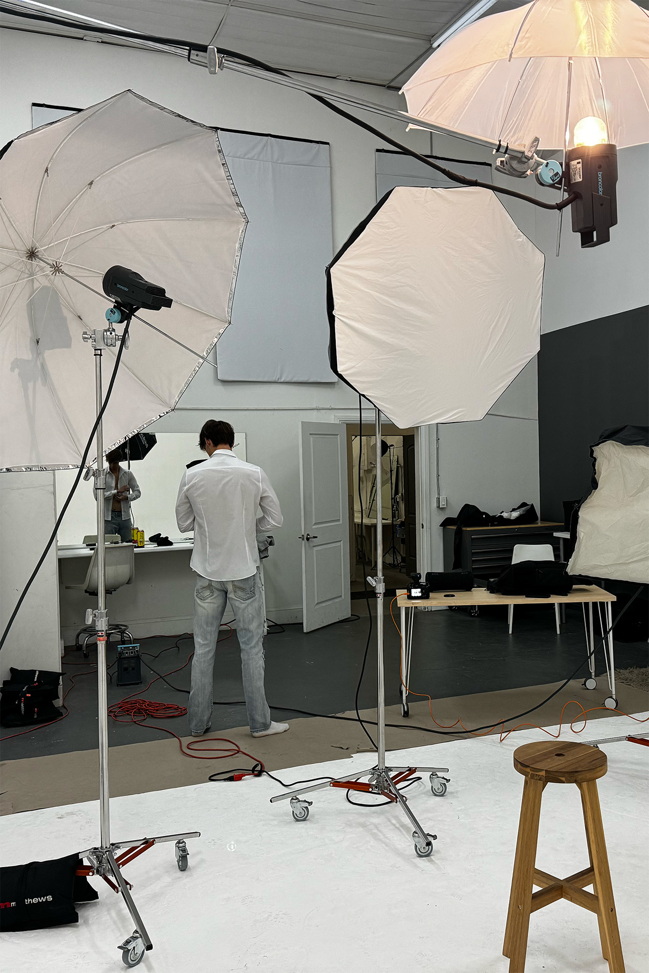 Behind-the-scenes photo of a white cyclorama studio set with softbox lighting equipment