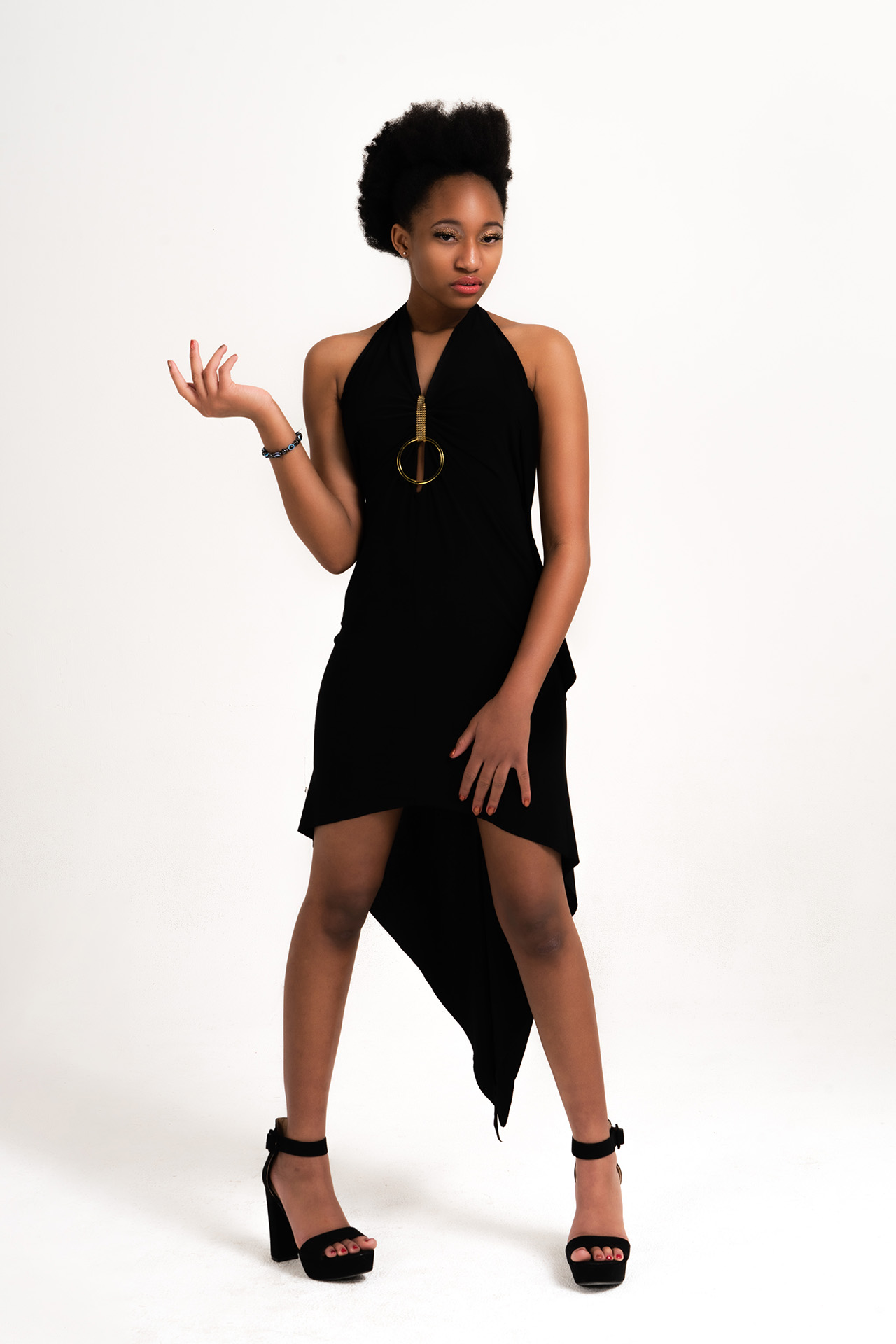 Model in a black asymmetrical dress with a statement necklace, dynamic editorial pose