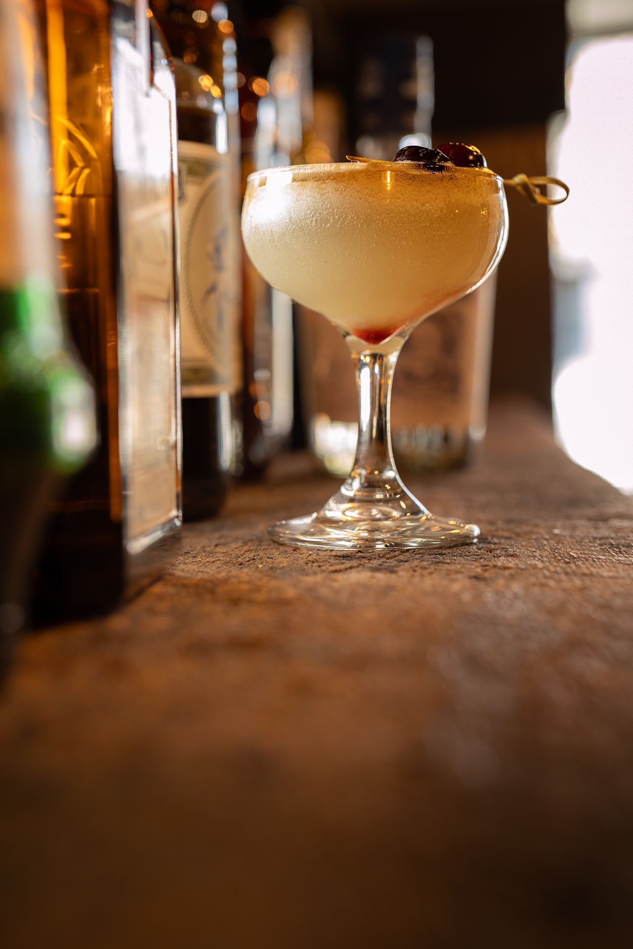 Absinthe of Fall cocktail, a tiki-inspired winter drink with a cherry garnish, at Pretty Neat Bar