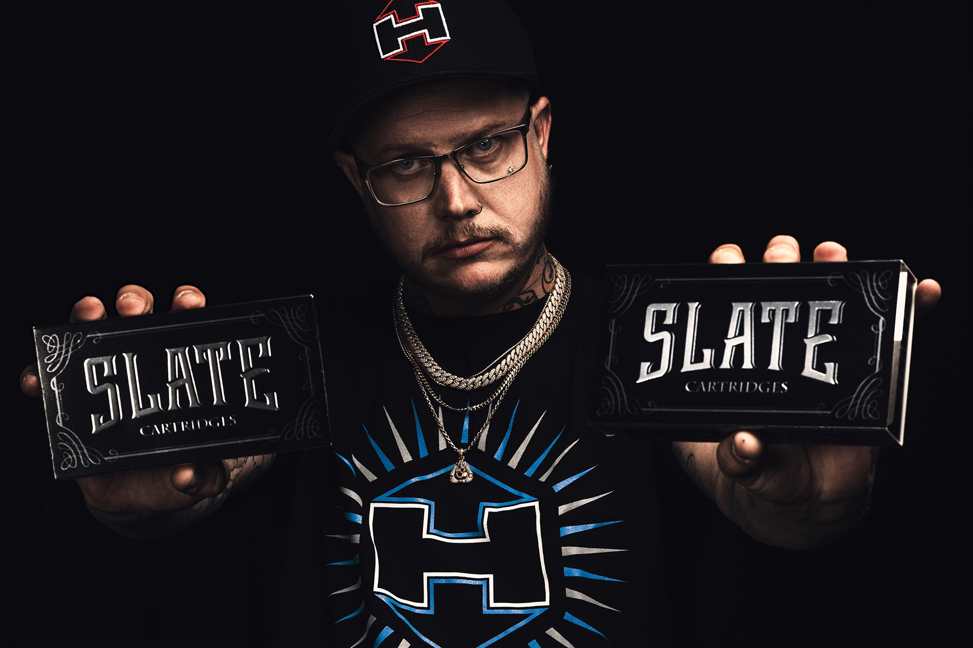 Zack holding 'Slate' products, Black Sheep Tattoo staff portrait