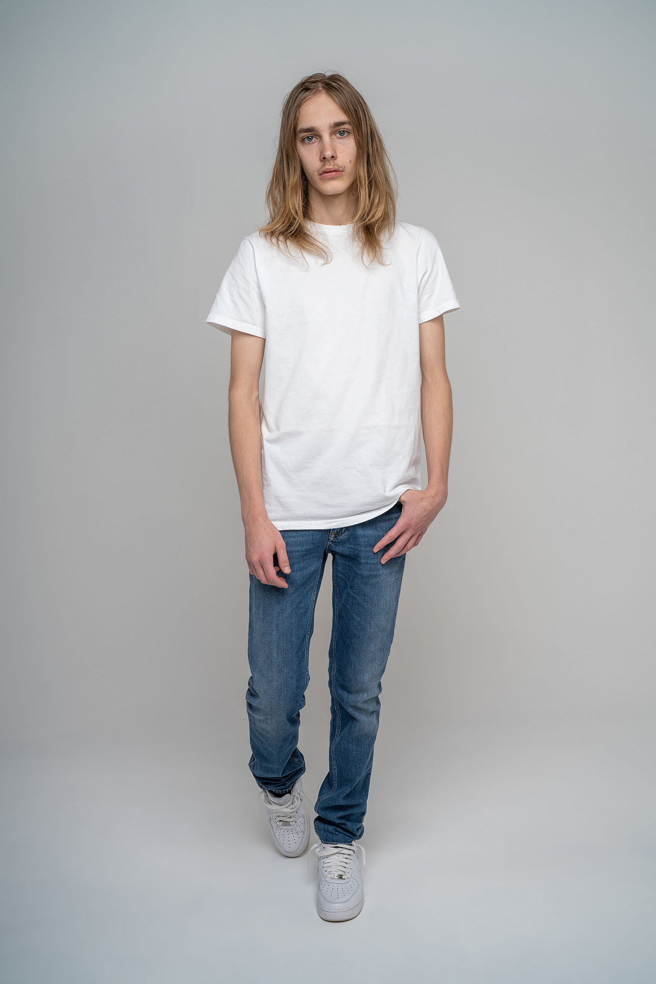 Full-body male model portfolio digital standing in jeans and white sneakers