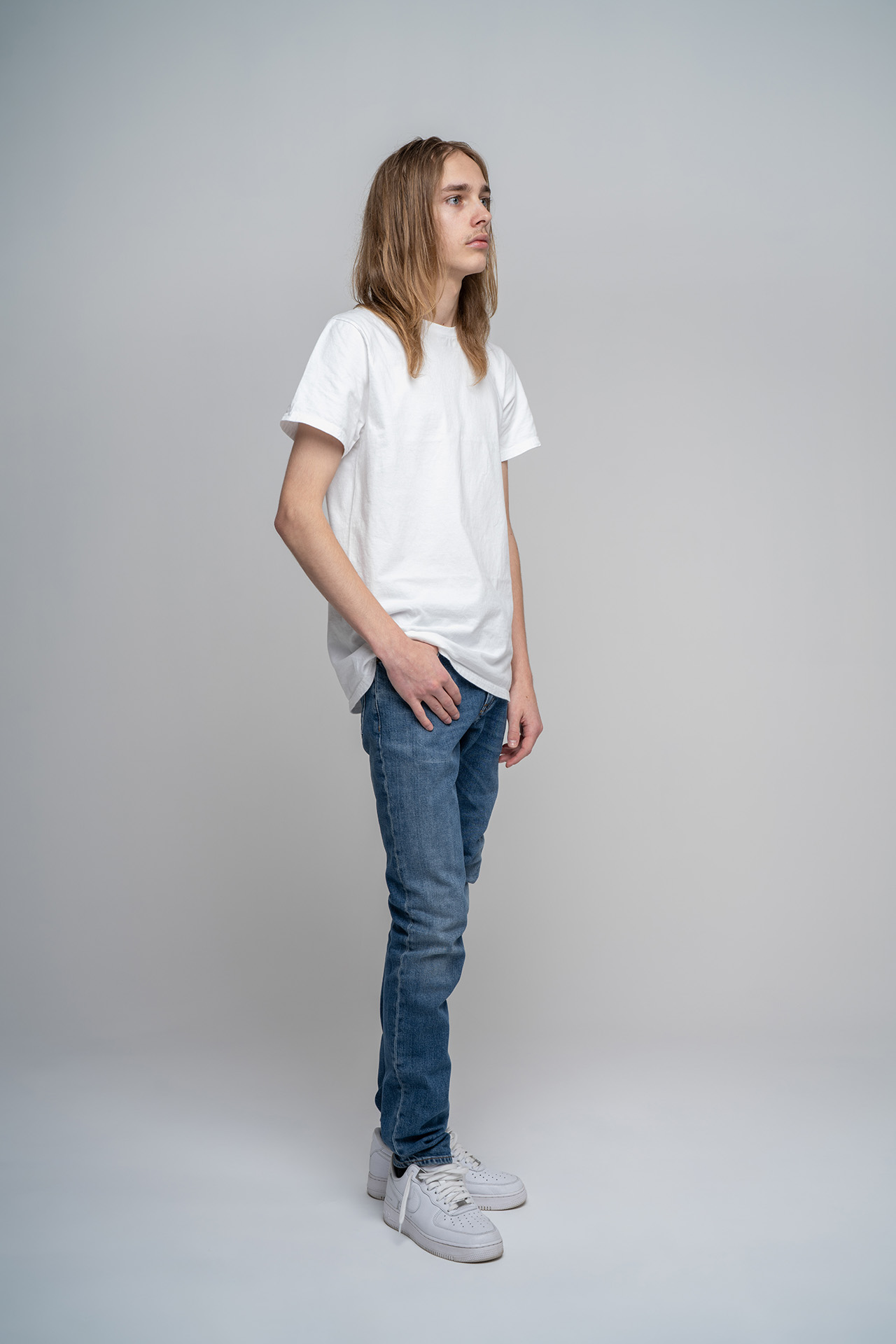 Full-body male model portfolio digital with hand in pocket, jeans and sneakers