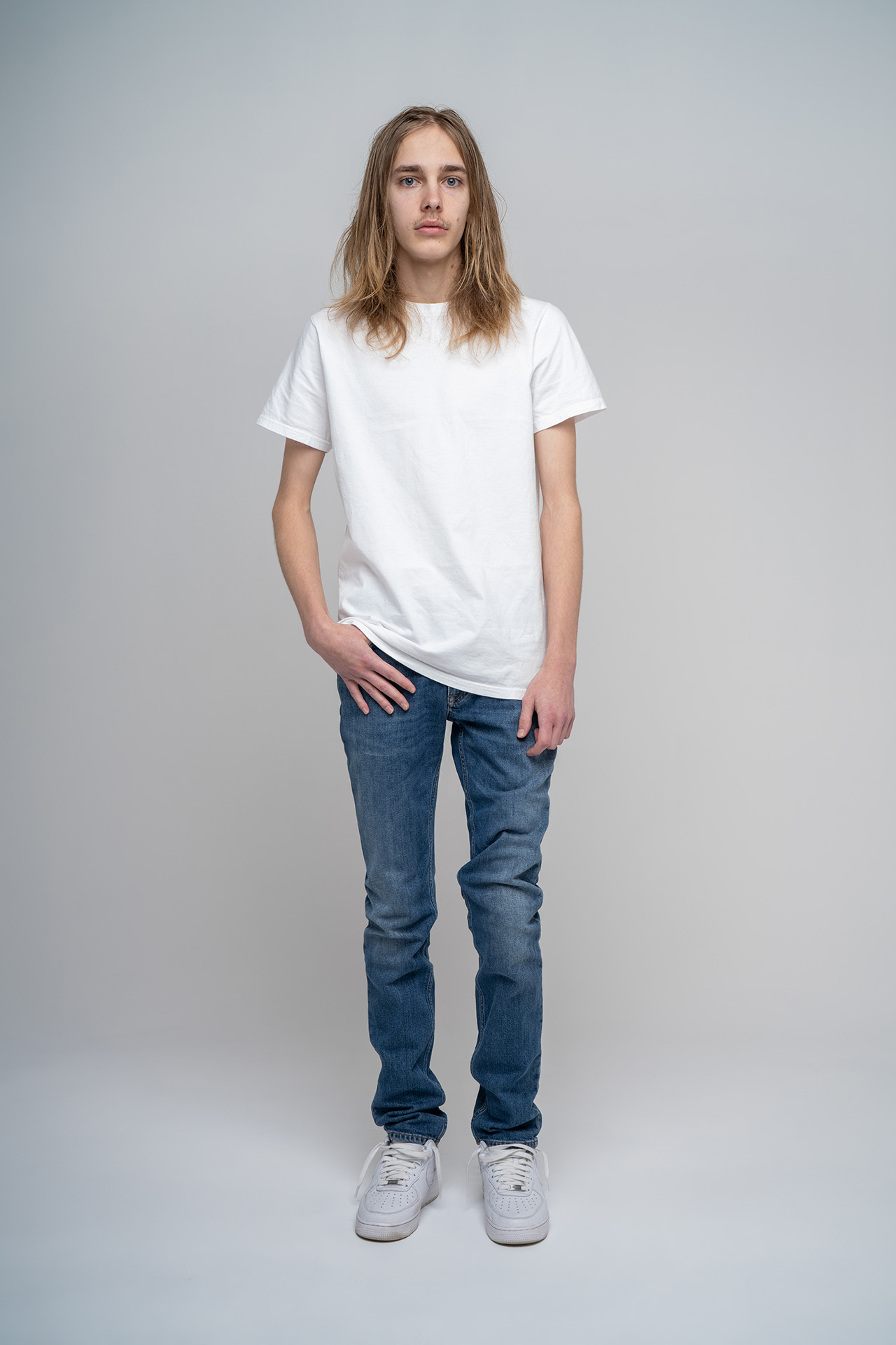 Full-body male model portfolio digital standing in jeans and sneakers, alternate angle