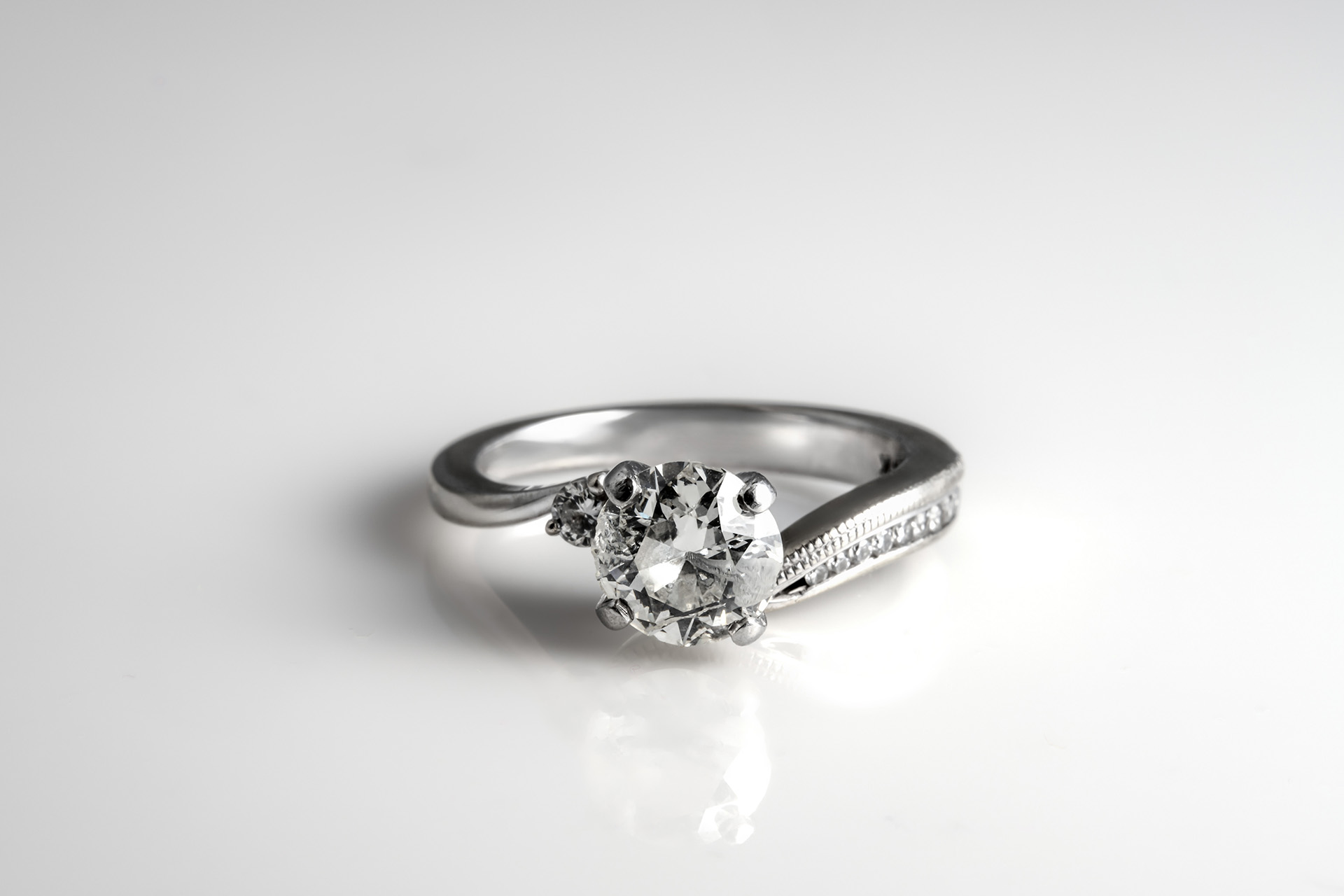 Product photography of a solitaire diamond engagement ring on a white background