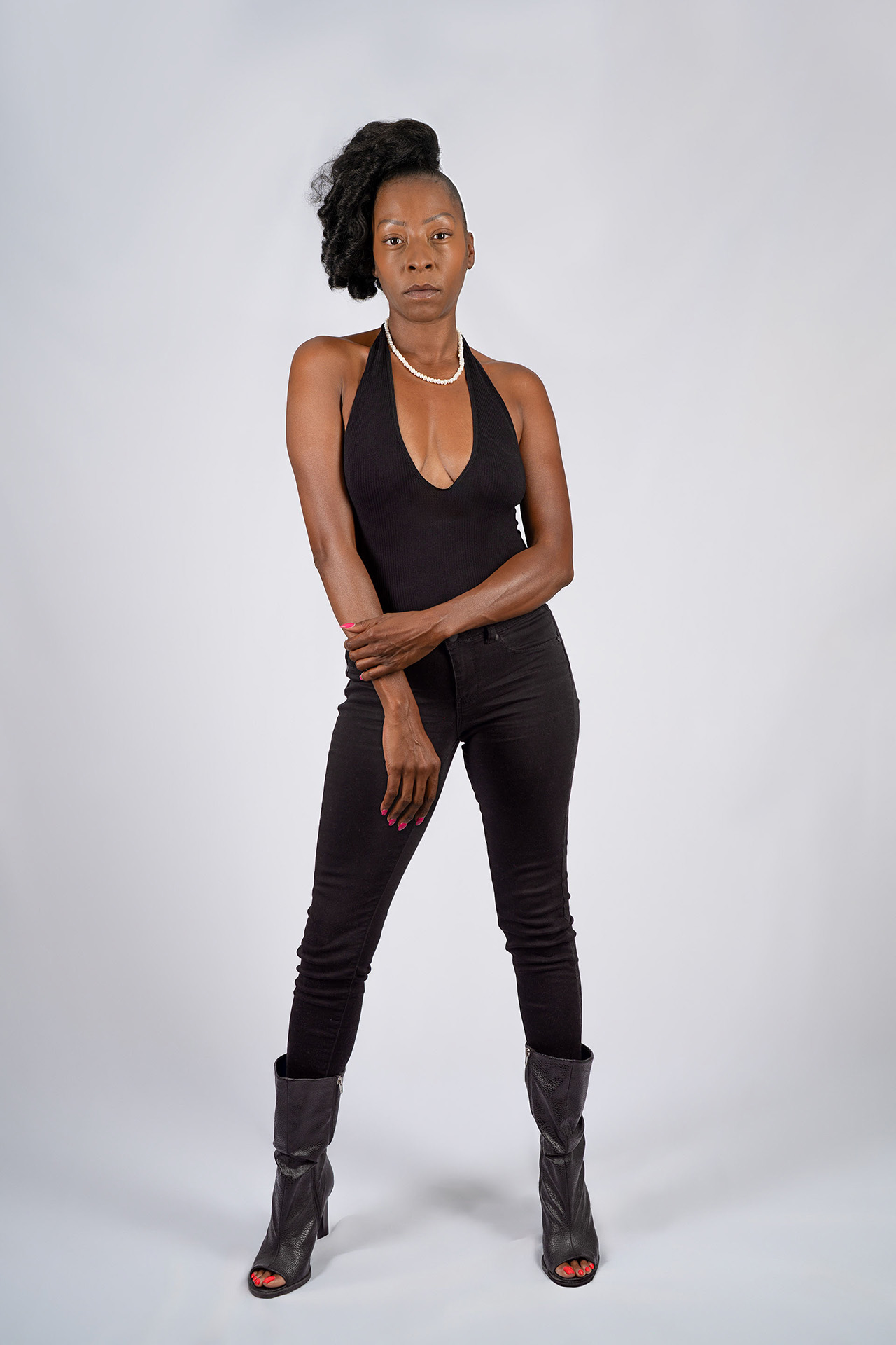 Full-body model portfolio digital standing with arms loosely crossed, black outfit and heels