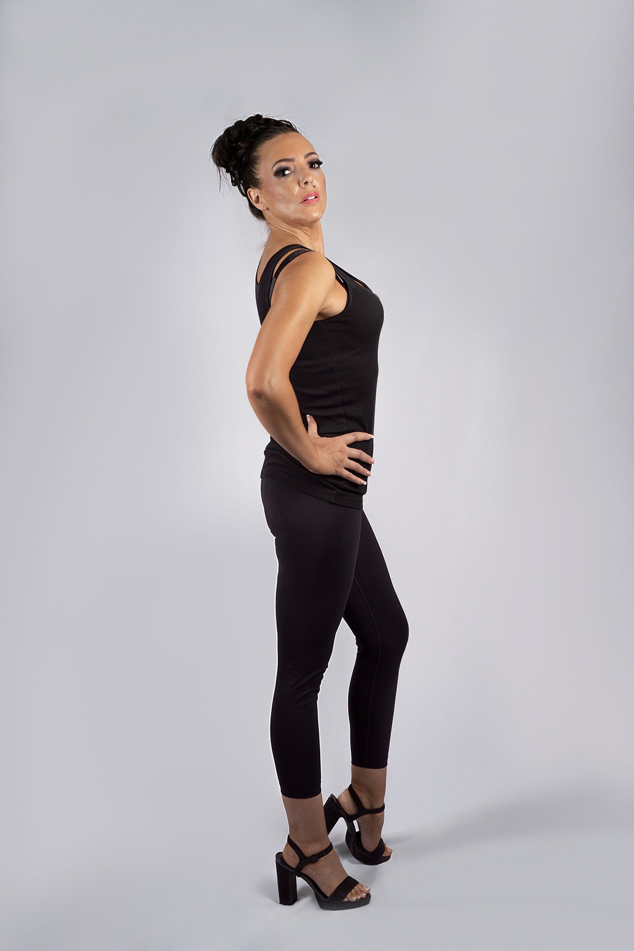 Full-body model portfolio digital in side profile with hand on hip, black outfit and heels