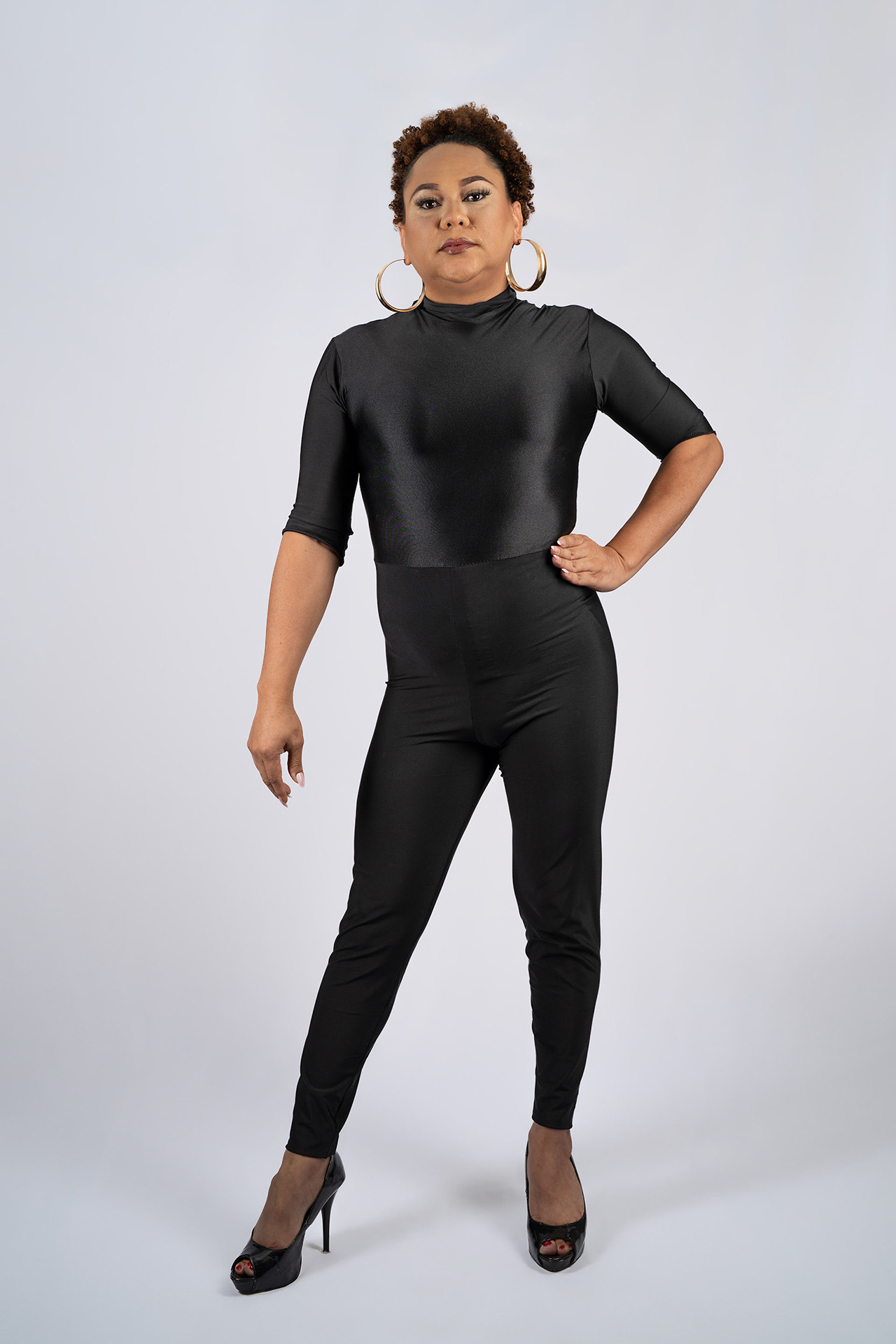 Full-body model portfolio digital in a black catsuit, side pose with hand on hip