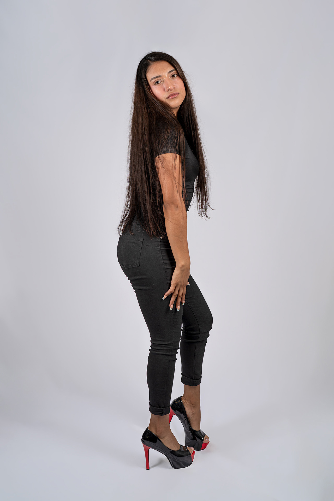 Full-body model portfolio digital in side angle, long hair down, black outfit and heels