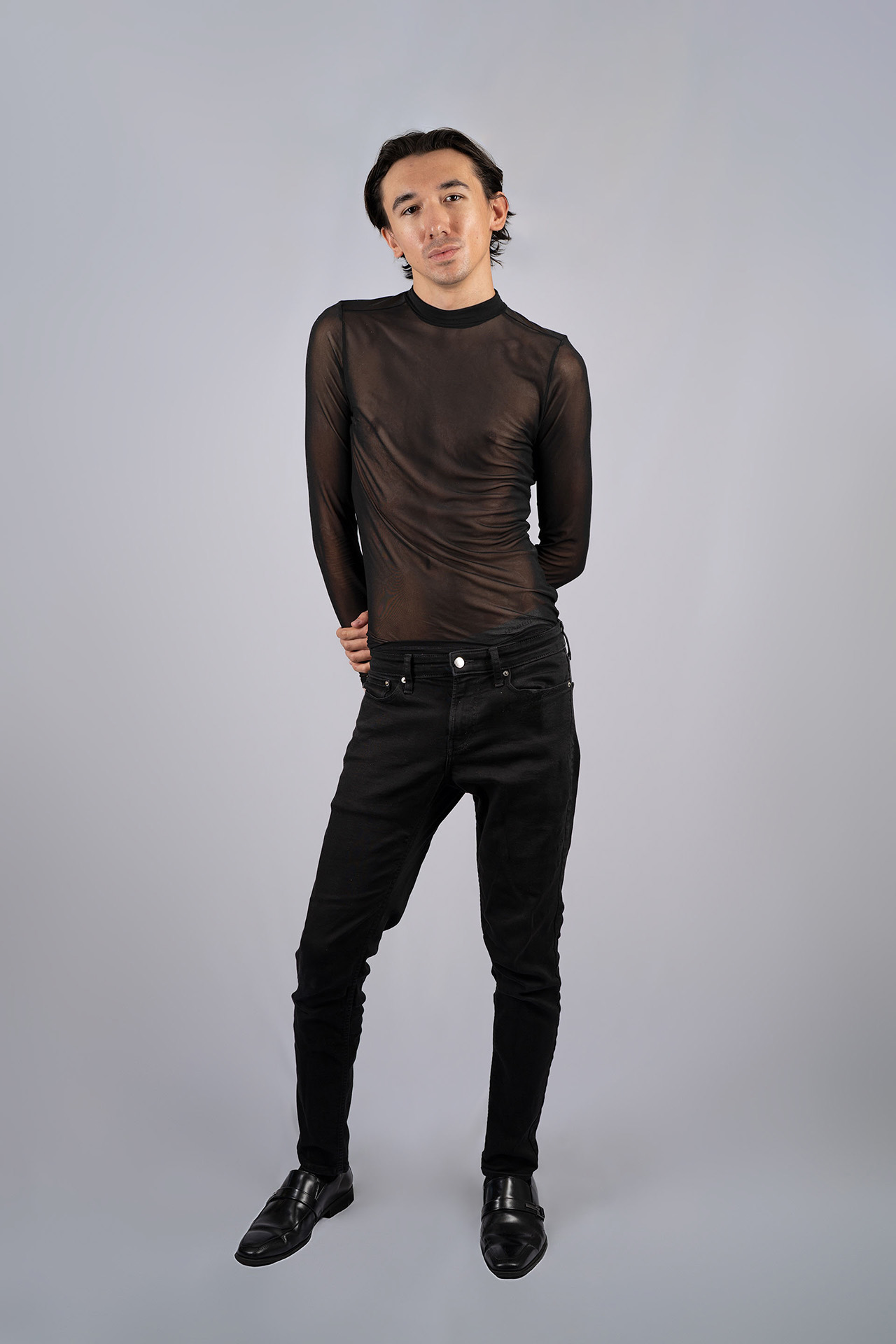 Full-body male model portfolio digital in a sheer black mesh top and pants, front view