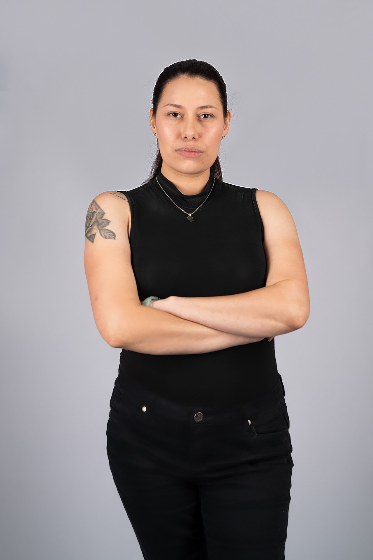 Half-body model portfolio digital with visible tattoos, arms crossed, black outfit