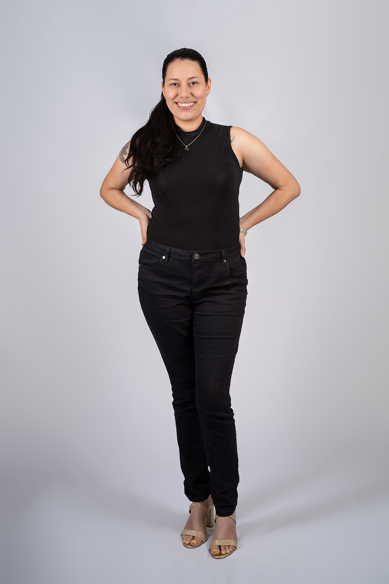 Full-body model portfolio digital smiling with hand on hip, black top and jeans