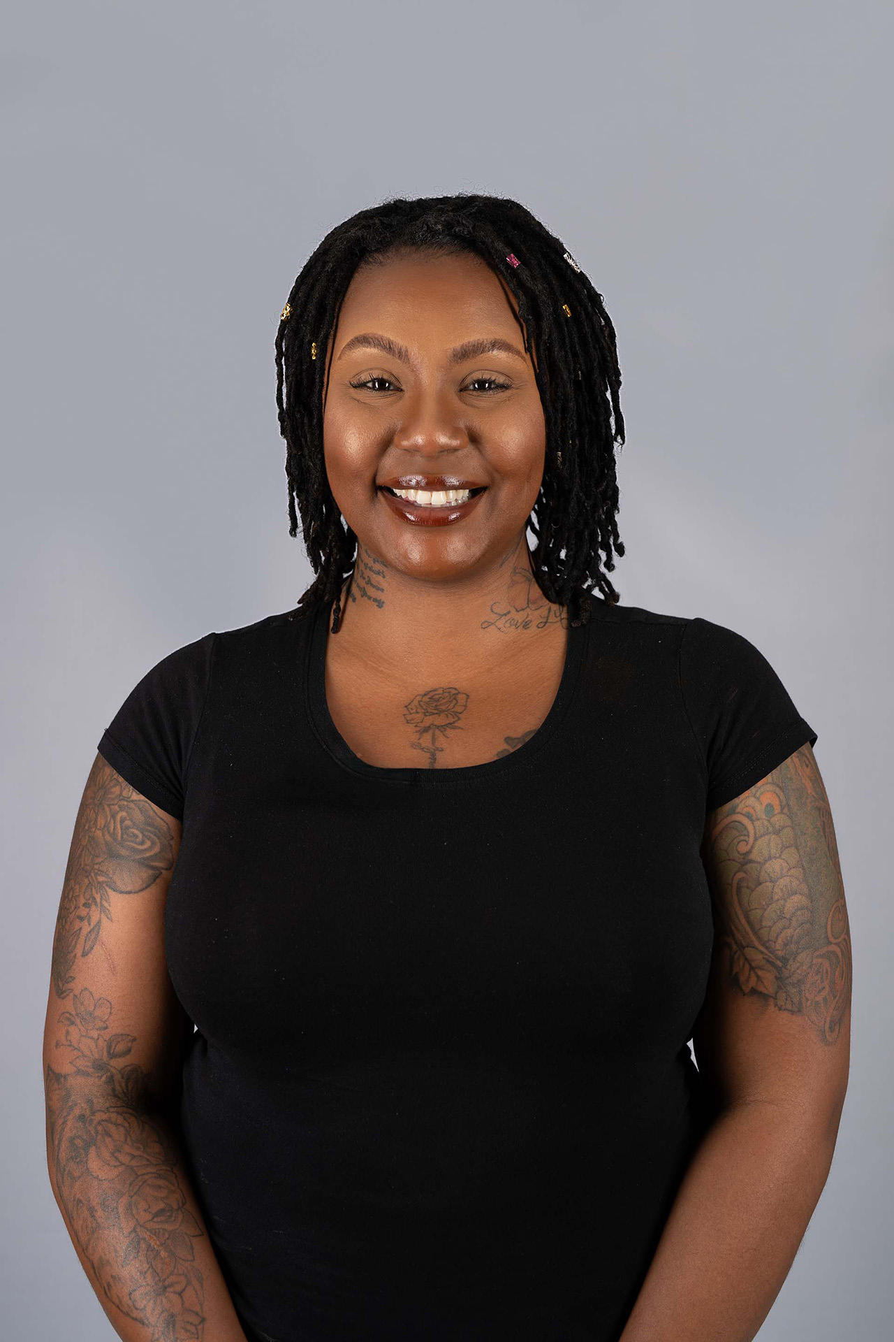 Model portfolio digital with braided hair, smiling, black top, gray studio background