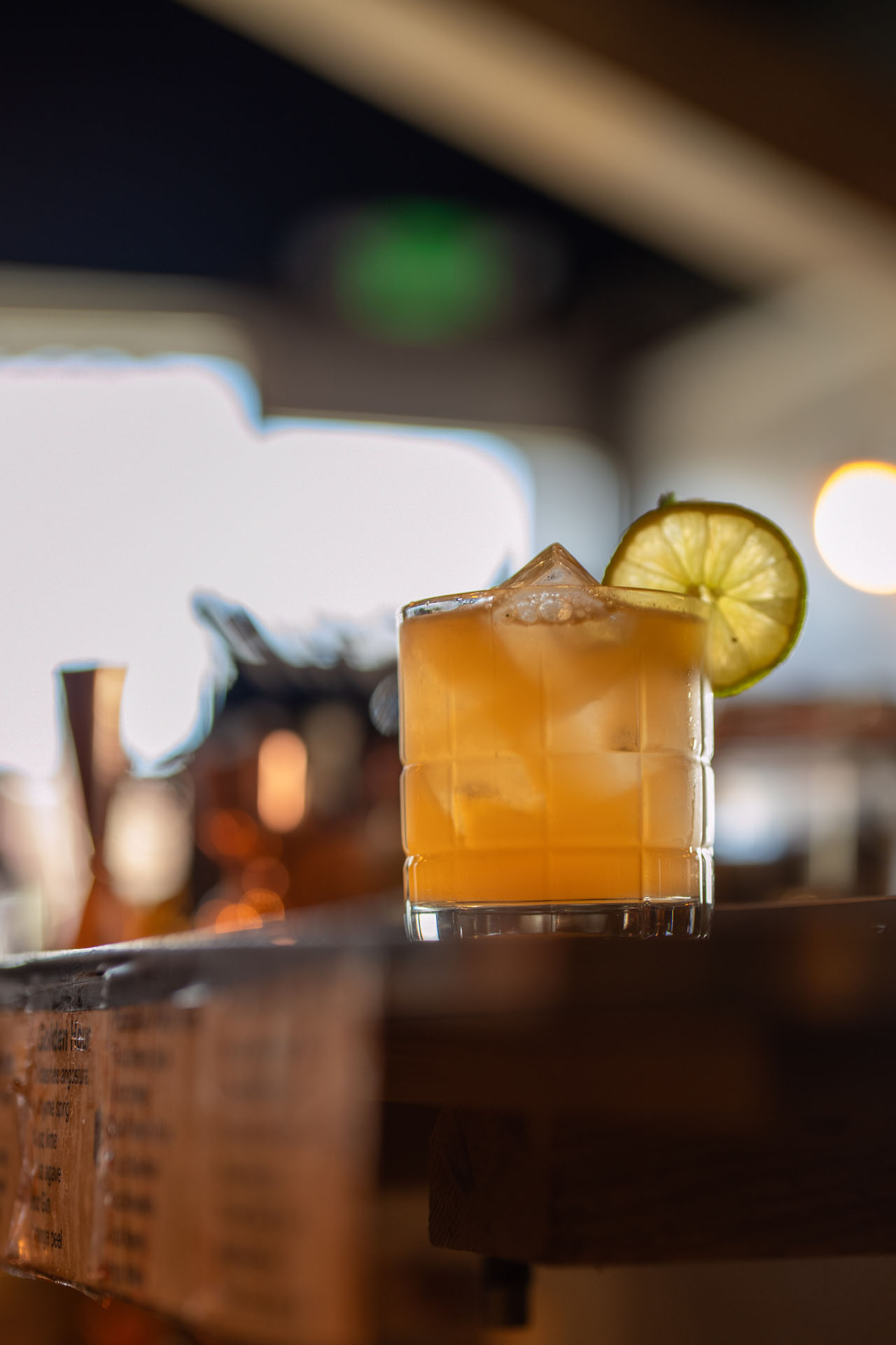 Gold Rush cocktail with a lime wheel garnish, alternate angle, at Pretty Neat Bar