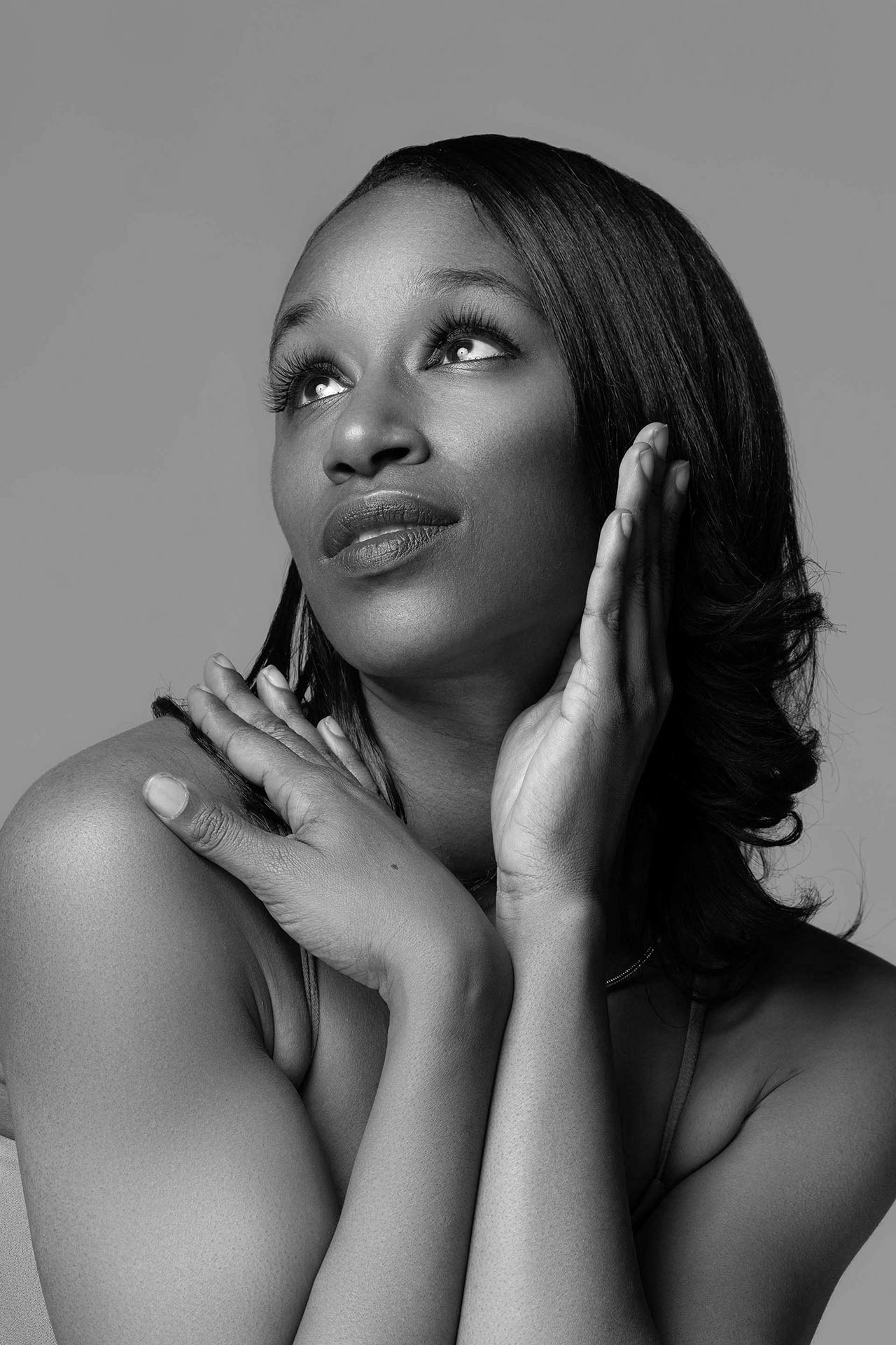 Black-and-white beauty portrait with hands framing the face and dramatic makeup, Aurora & Denver, CO