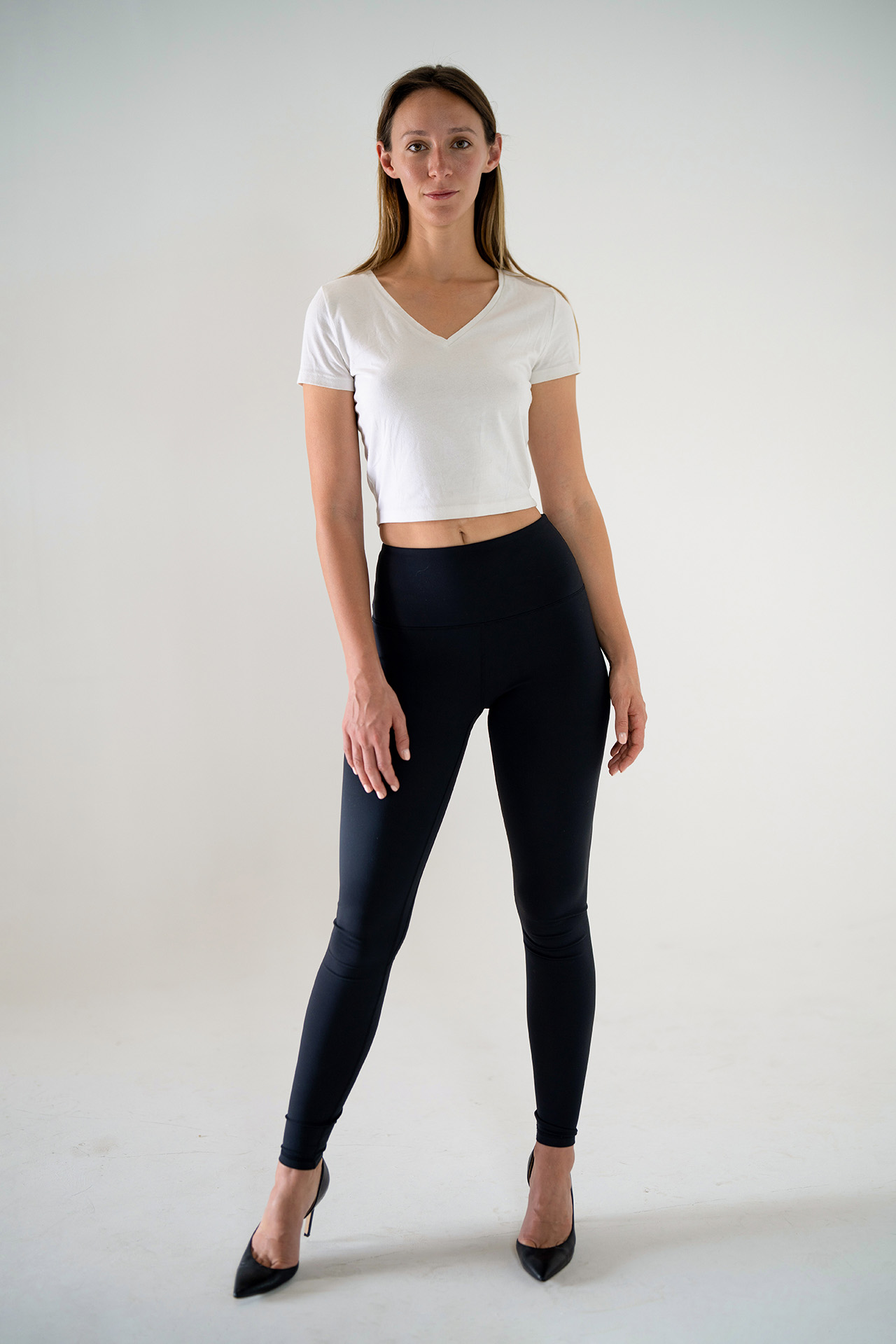 Full-body model portfolio digital standing straight in black leggings, neutral studio background