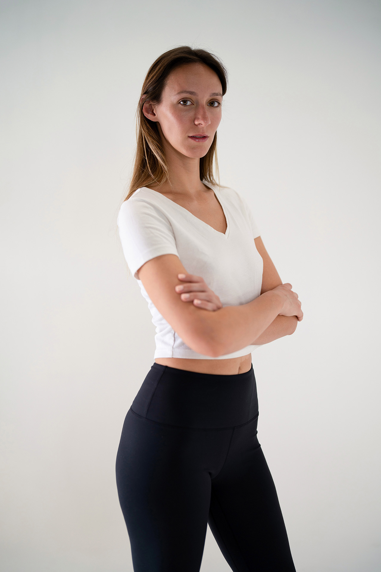 Full-body model portfolio digital with arms crossed, white top and black leggings