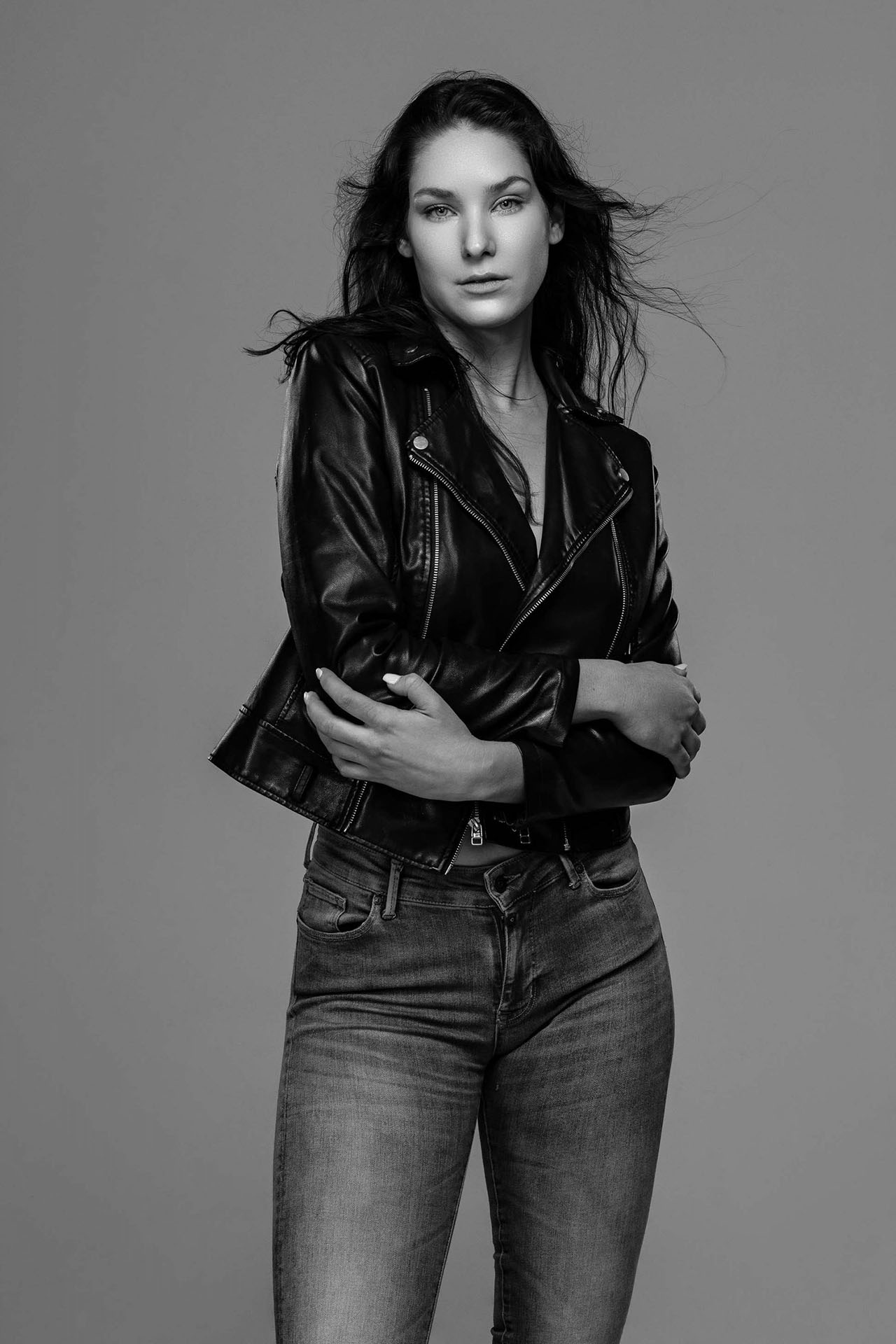 Black-and-white editorial portrait of a model in a leather jacket and jeans, Denver fashion photography