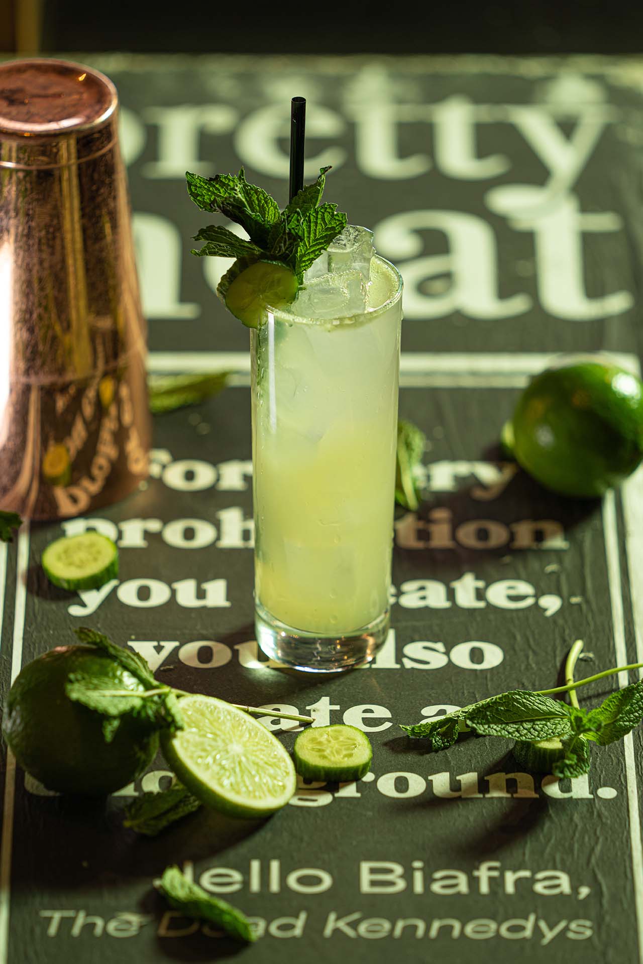 House twist on a classic mojito styled with mint, lime, and a branded book prop, at Pretty Neat Bar