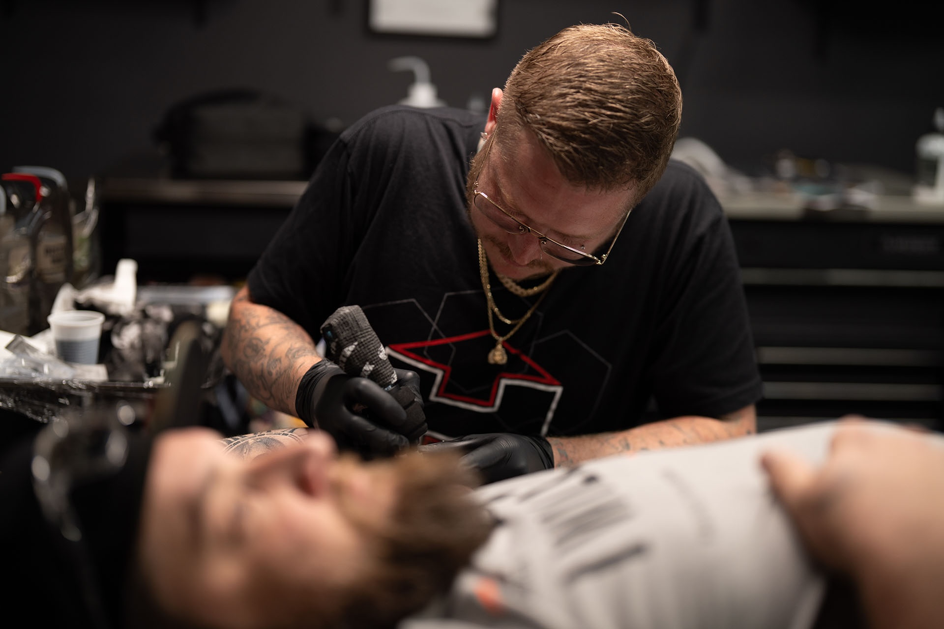 Tattoo artist at work inking a client's arm inside a Denver tattoo parlor